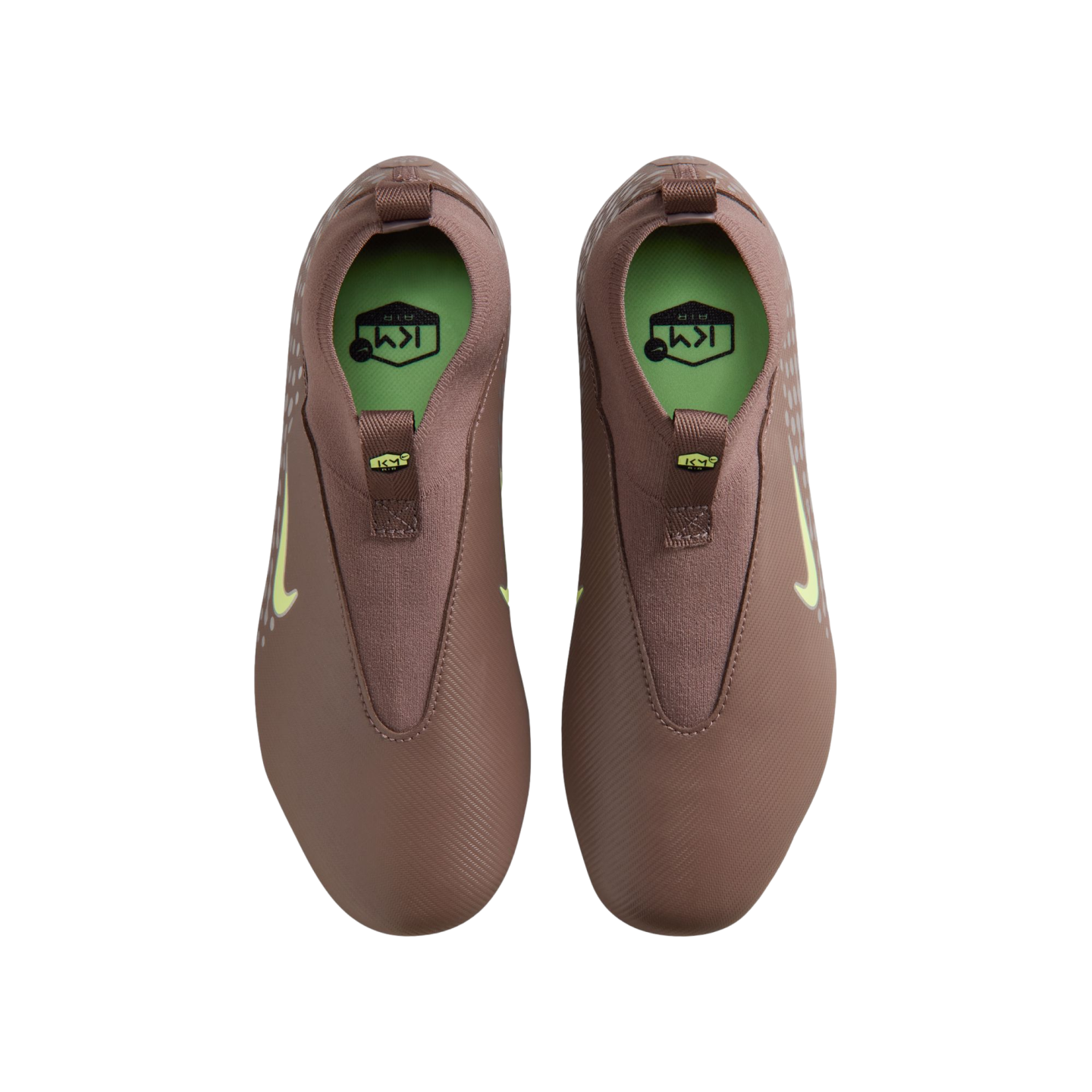 Top-down view of mauve Nike Kylian Mbappé soccer cleats with lime green accents and insoles, set against a solid black background.