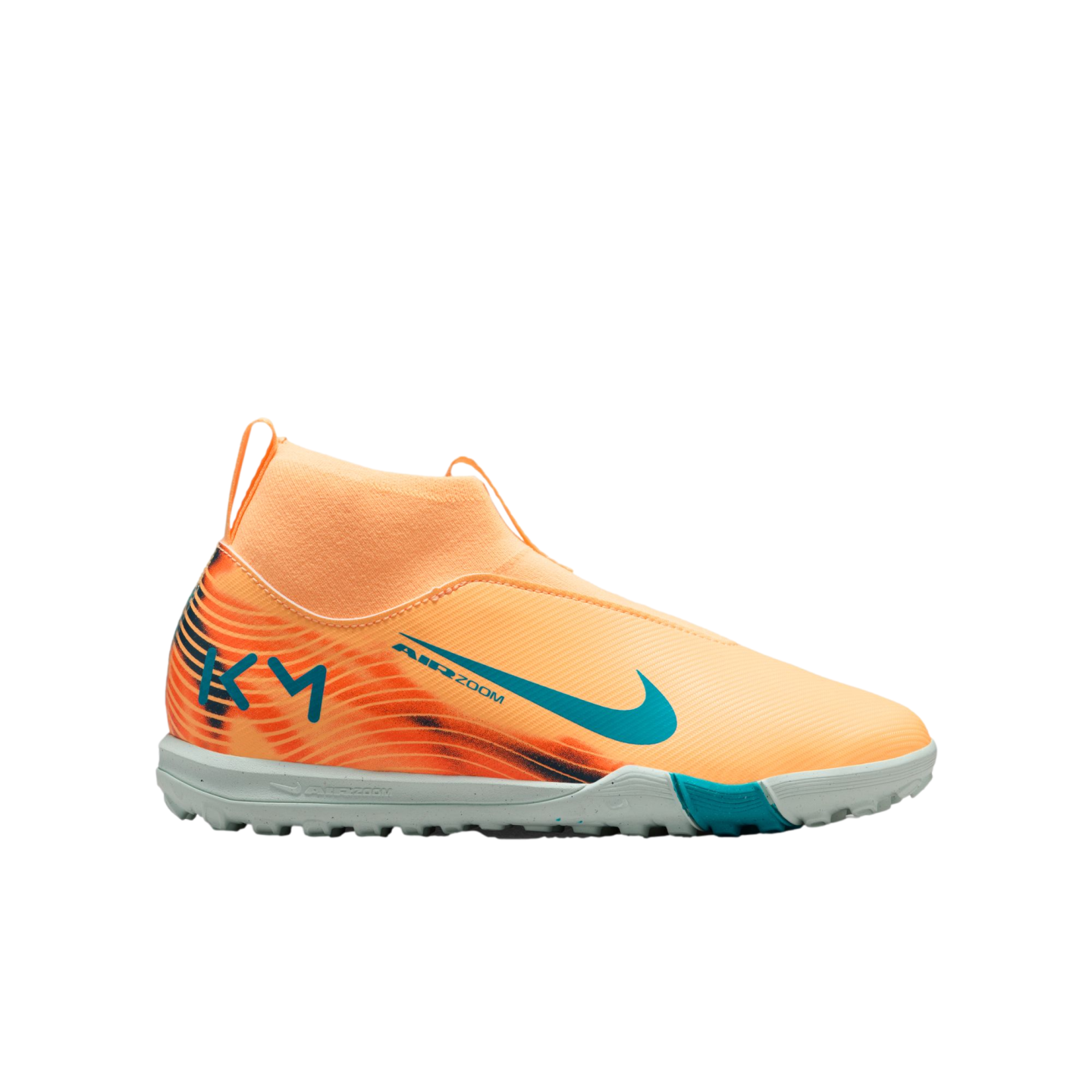A bright orange Nike soccer turf shoe with teal accents, a sock-like collar, and "KM" logo on the heel, shown against a solid black background.