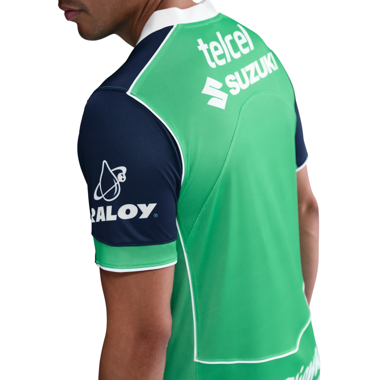 Back view of a man wearing a green sports jersey with navy blue sleeves, featuring white sponsor logos for Telcel, Suzuki, and Raloy.