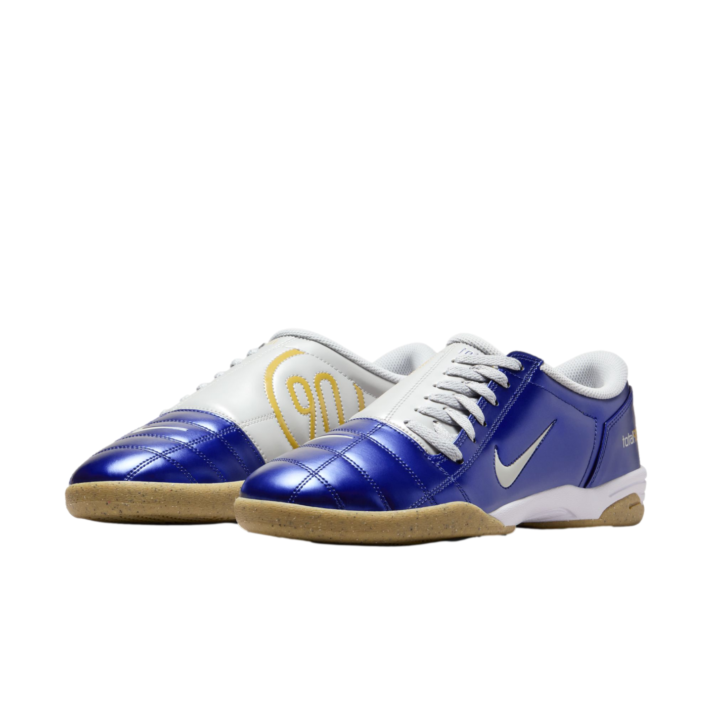 Pair of blue and white Nike Total 90 indoor soccer shoes with gum soles and yellow "90" logo on a solid black background.