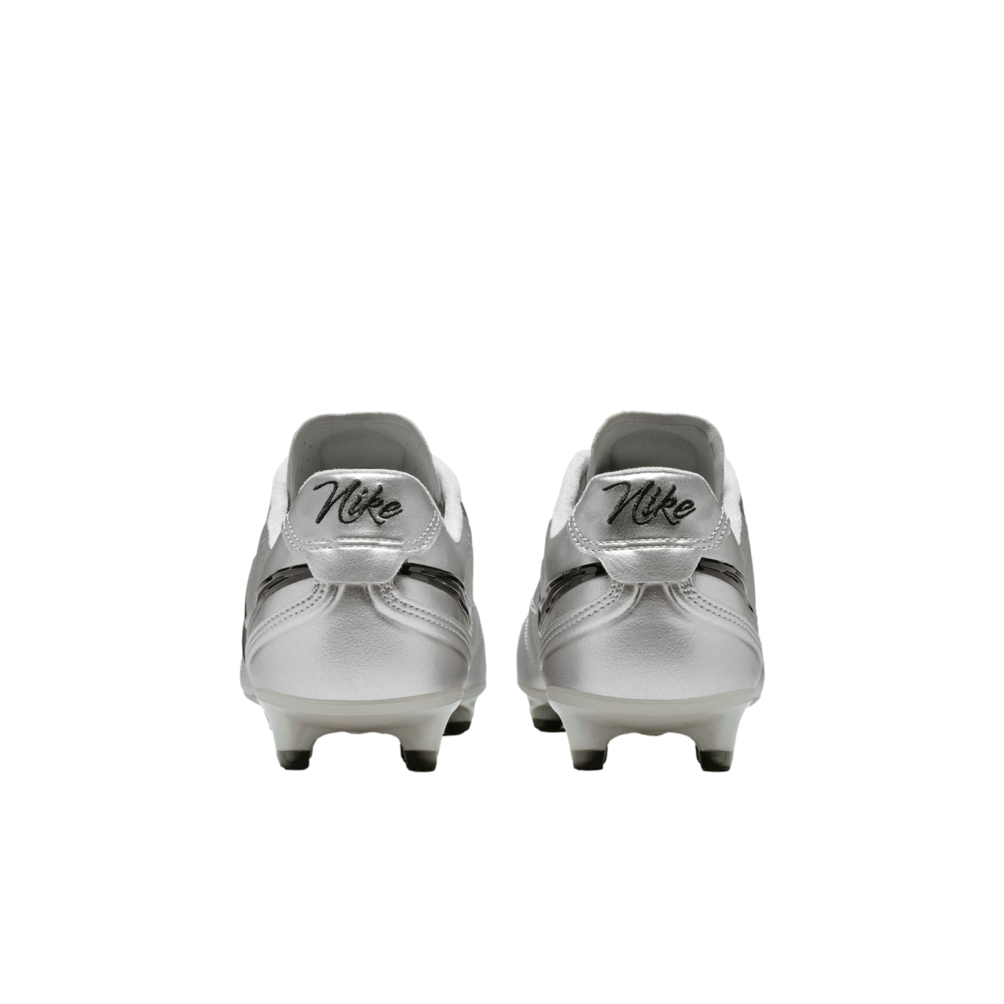 A rear view of a pair of metallic silver Nike soccer cleats with retro-style "Nike" script on the heels, set against a solid black background.