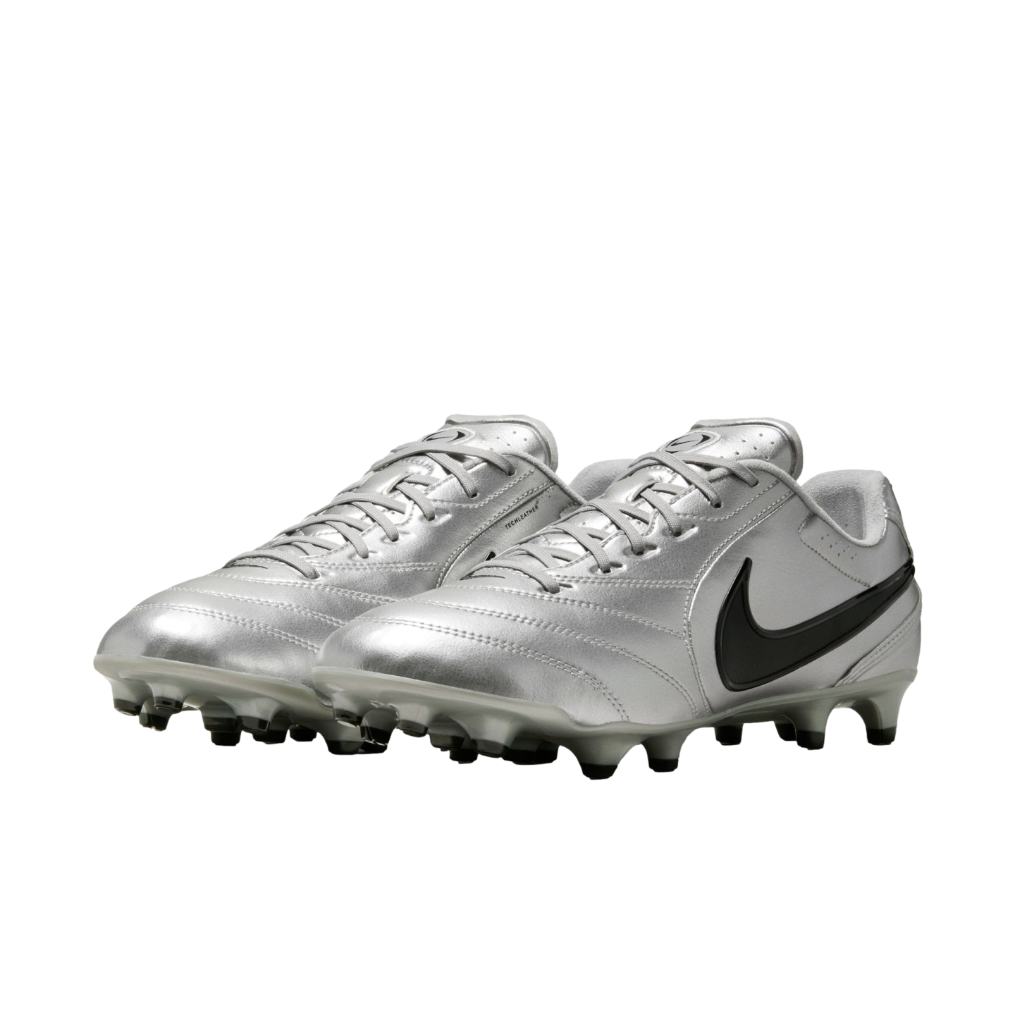 A pair of metallic silver Nike soccer cleats with a black swoosh and grey studs, shown from a three-quarter angle against a black background.