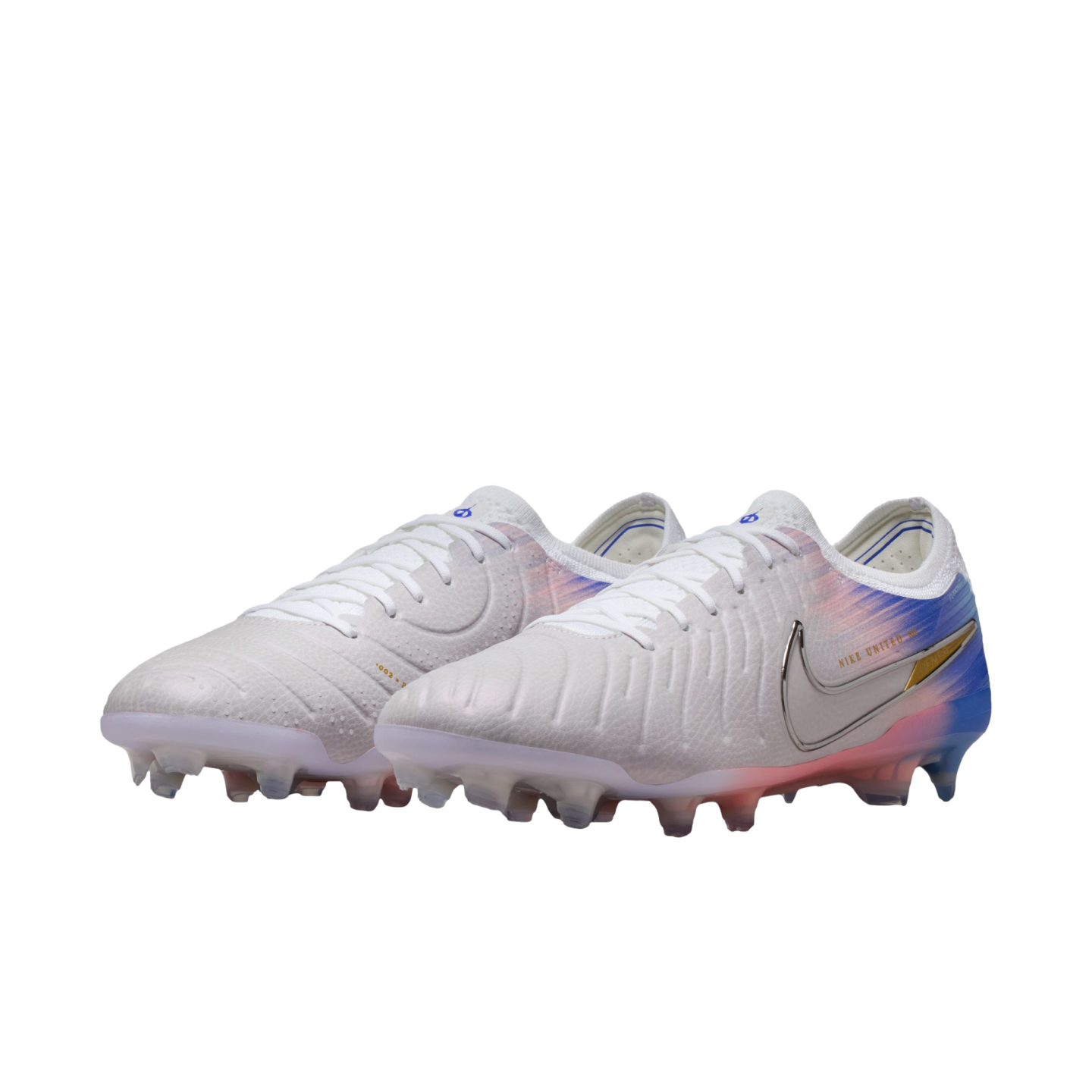 Pair of white Nike soccer cleats with a blue and orange gradient heel and a silver Nike swoosh, set against a black background.