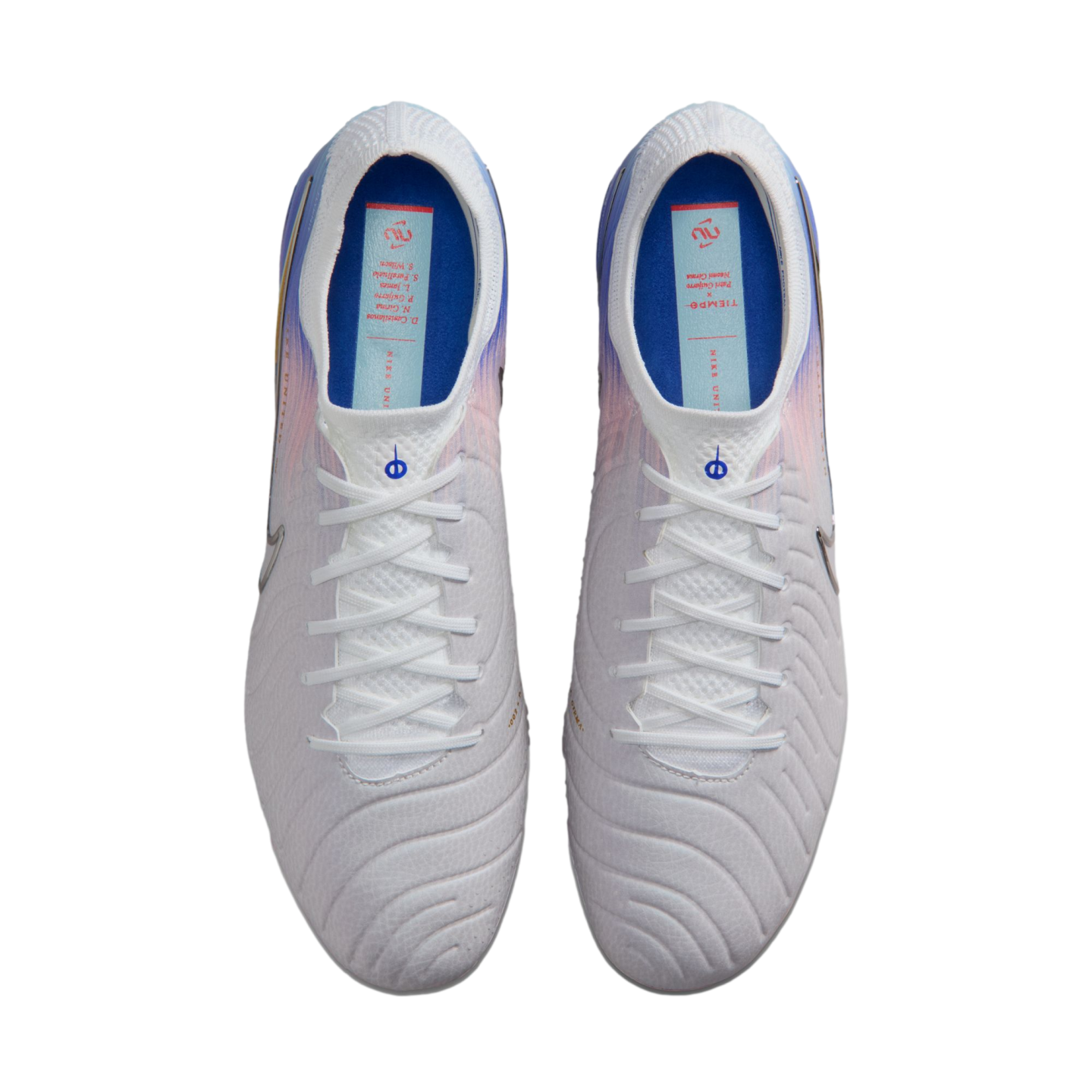 Top-down view of a pair of white Nike soccer cleats on a black background, featuring blue interiors and light blue and orange accents near the heel.