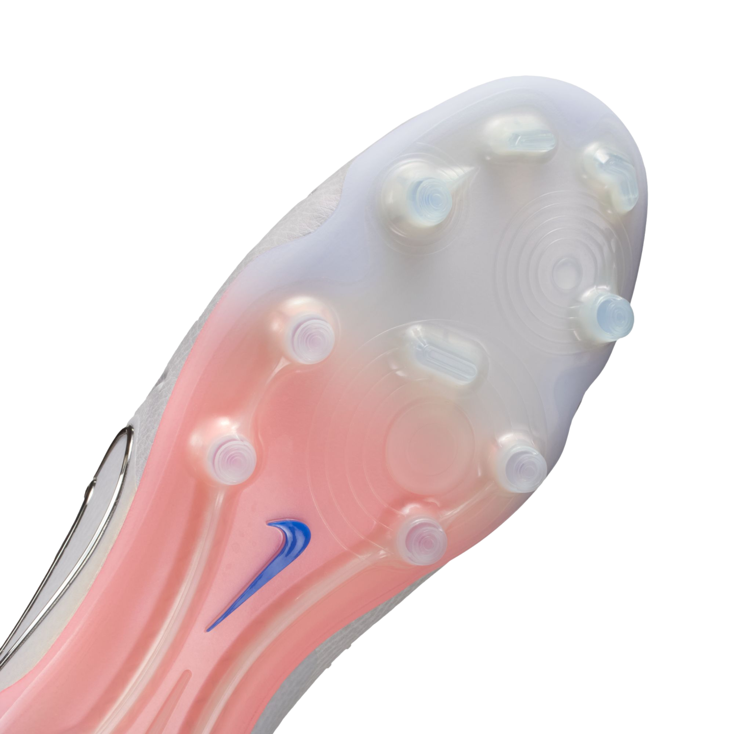 Close-up of a Nike soccer cleat's translucent soleplate featuring a white-to-pink gradient, clear circular studs, and a small blue swoosh logo.