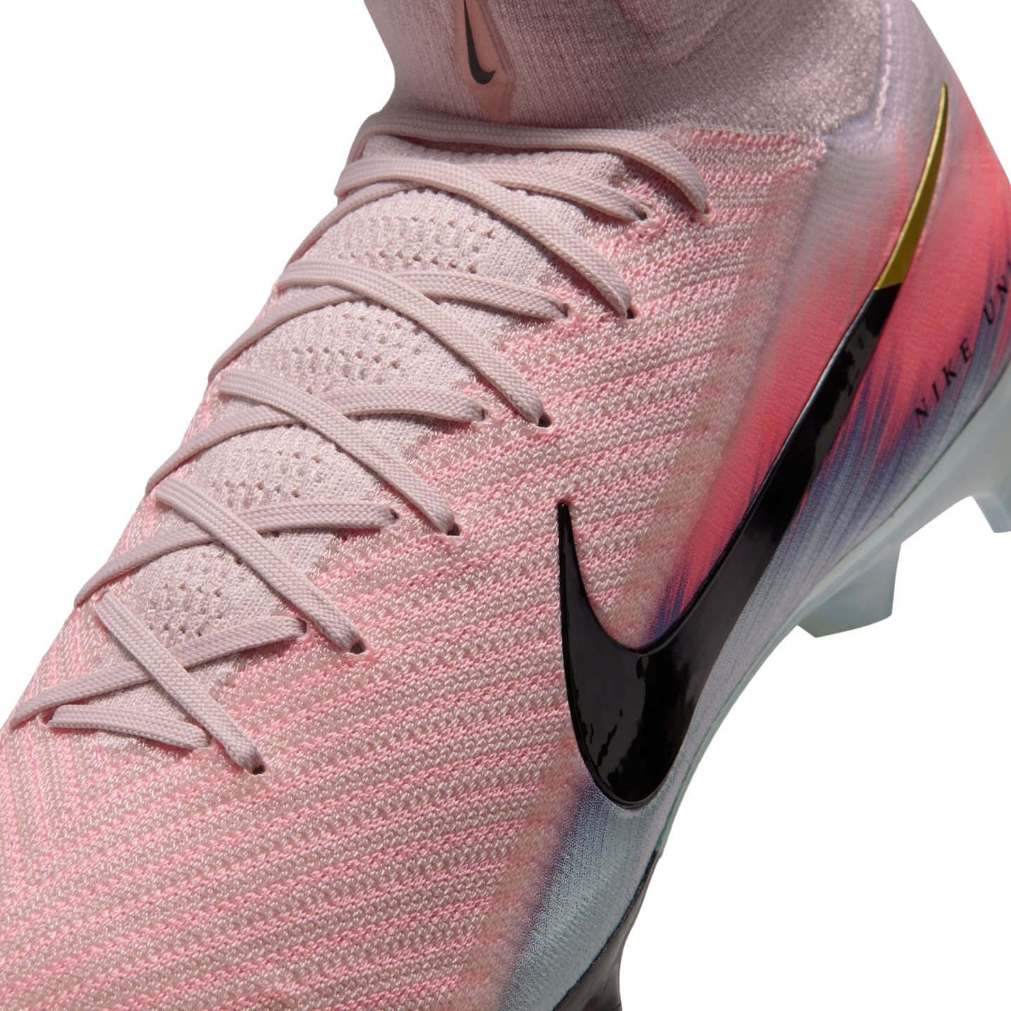 Close-up of a pink Nike soccer cleat with a textured Flyknit upper, pink laces, a large black swoosh, and a vibrant color gradient.