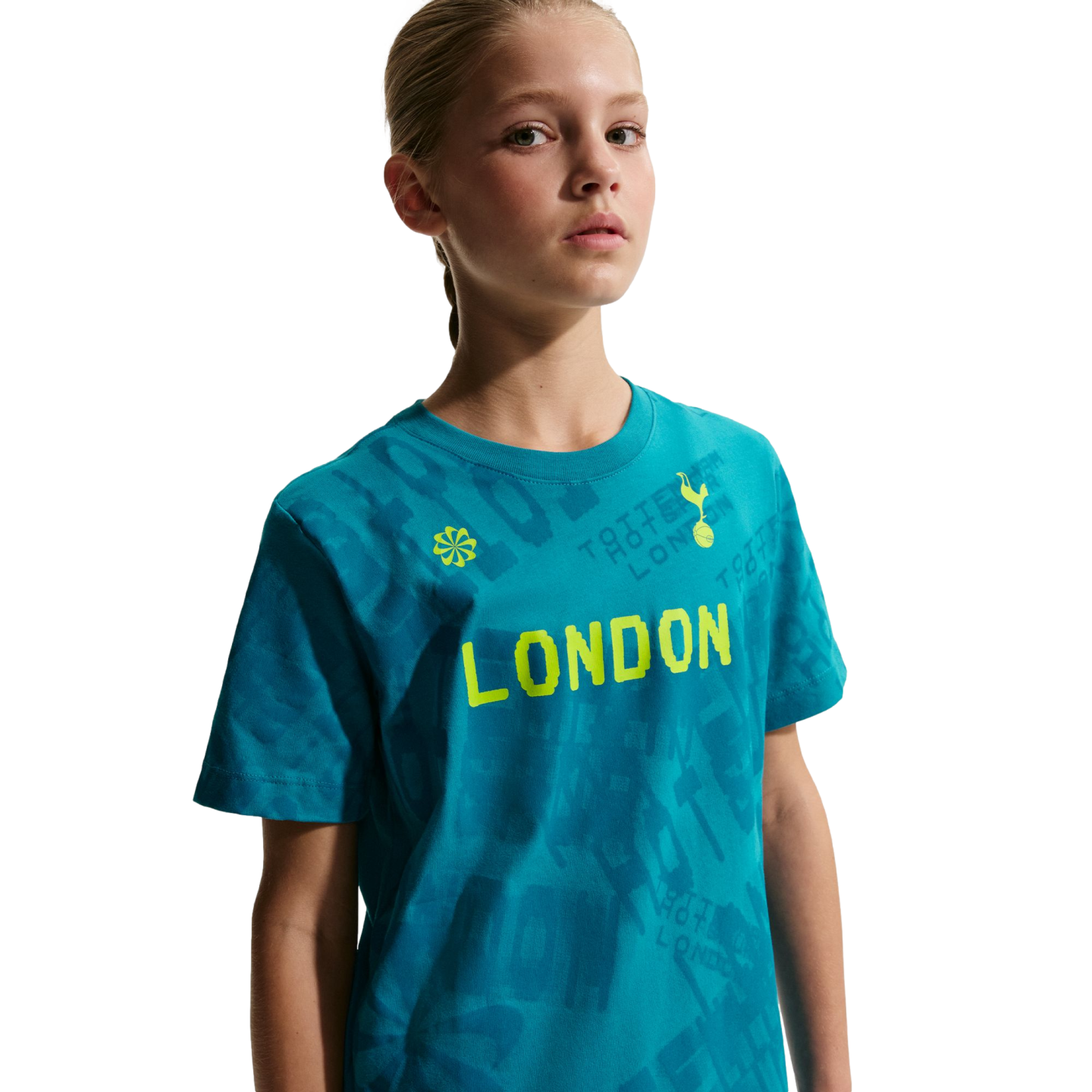 Young girl wearing a teal T-shirt with "LONDON" in neon yellow and the Tottenham Hotspur logo, against a black background.