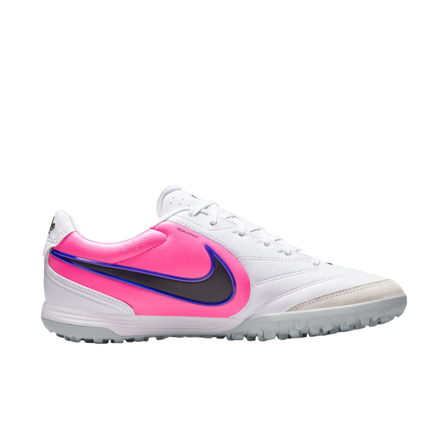 Profile view of a white Nike turf soccer shoe featuring a vibrant pink side panel, a blue-outlined black swoosh, and a textured grey rubber outsole.