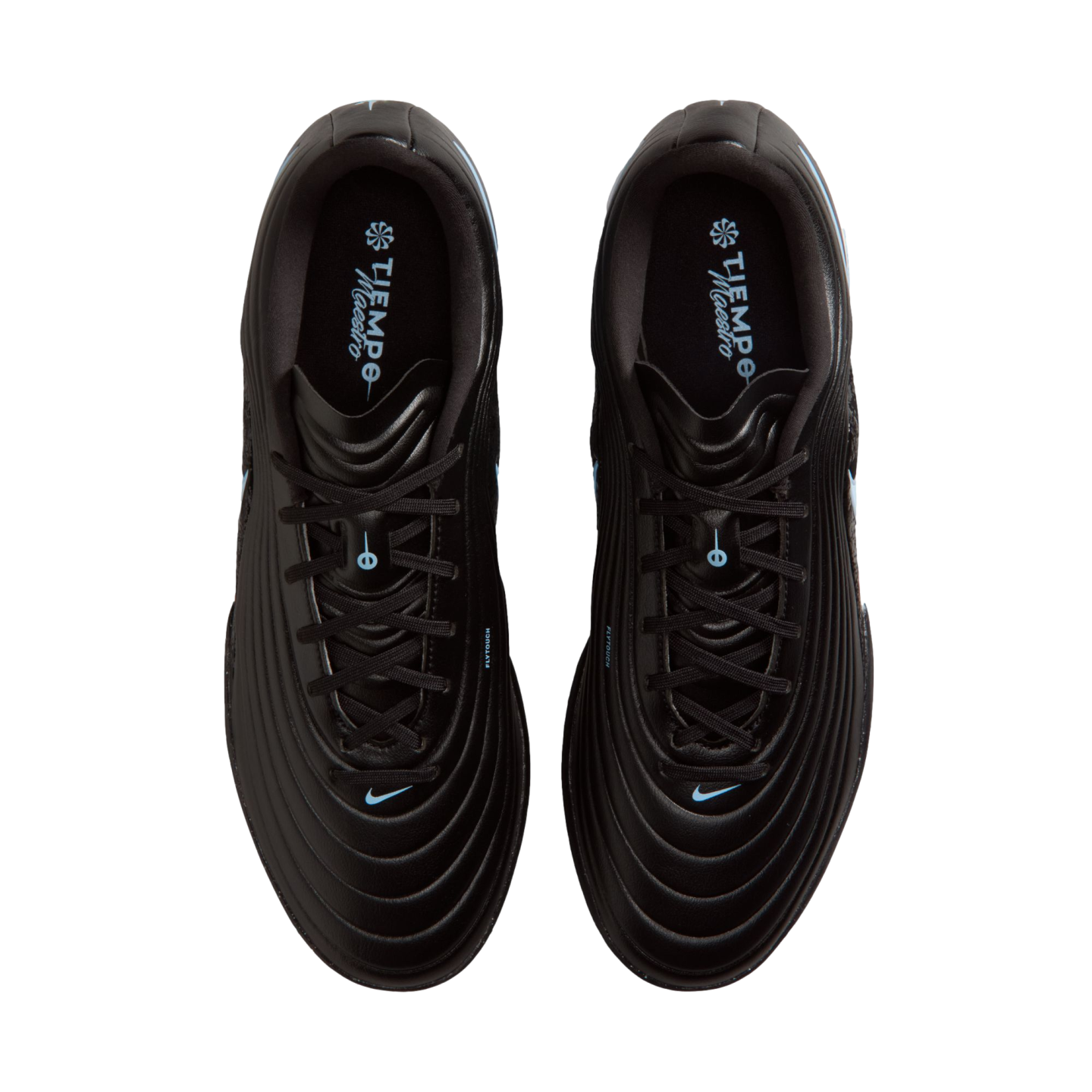 Top-down view of a pair of black Nike Tiempo Maestro soccer cleats with light blue accents and a circular stitched upper pattern, against a solid black background.
