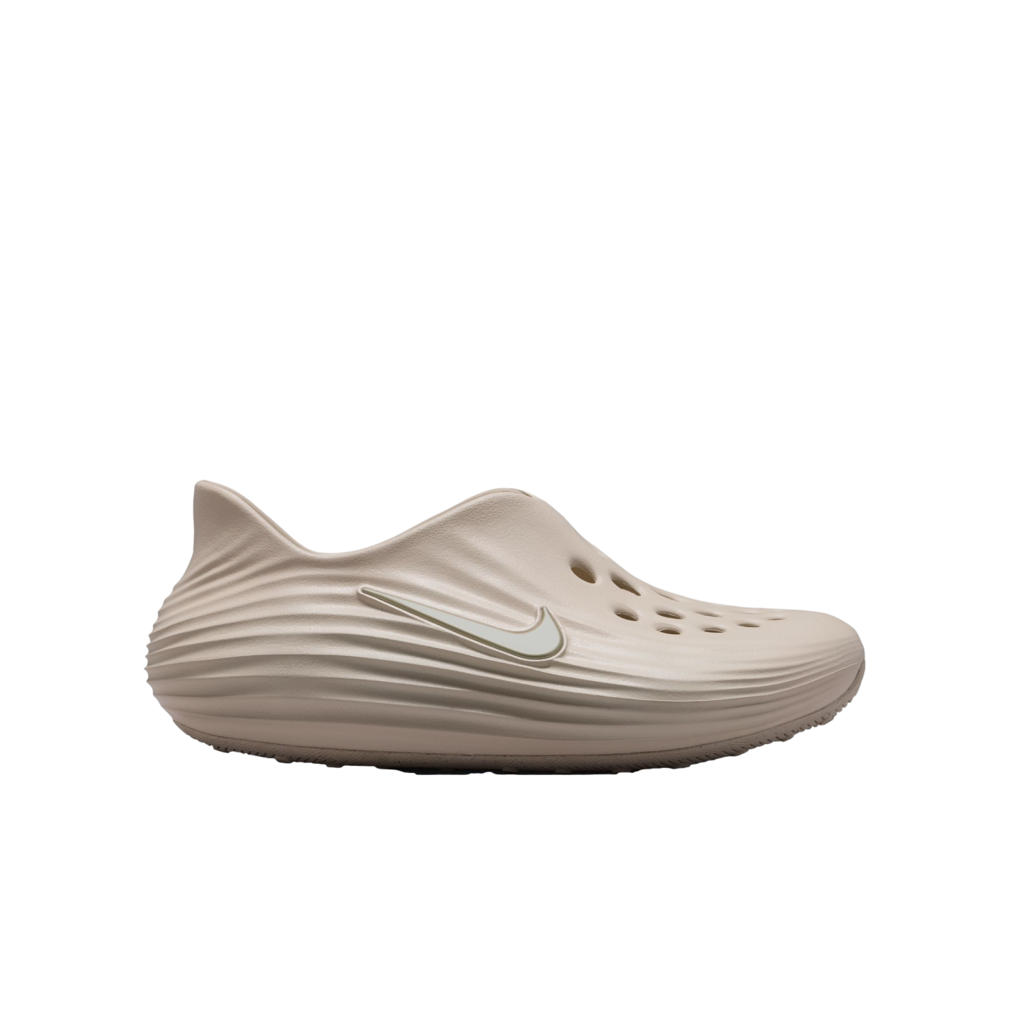 Profile view of a light beige Nike foam clog with a white swoosh and top perforations, isolated on a black background.