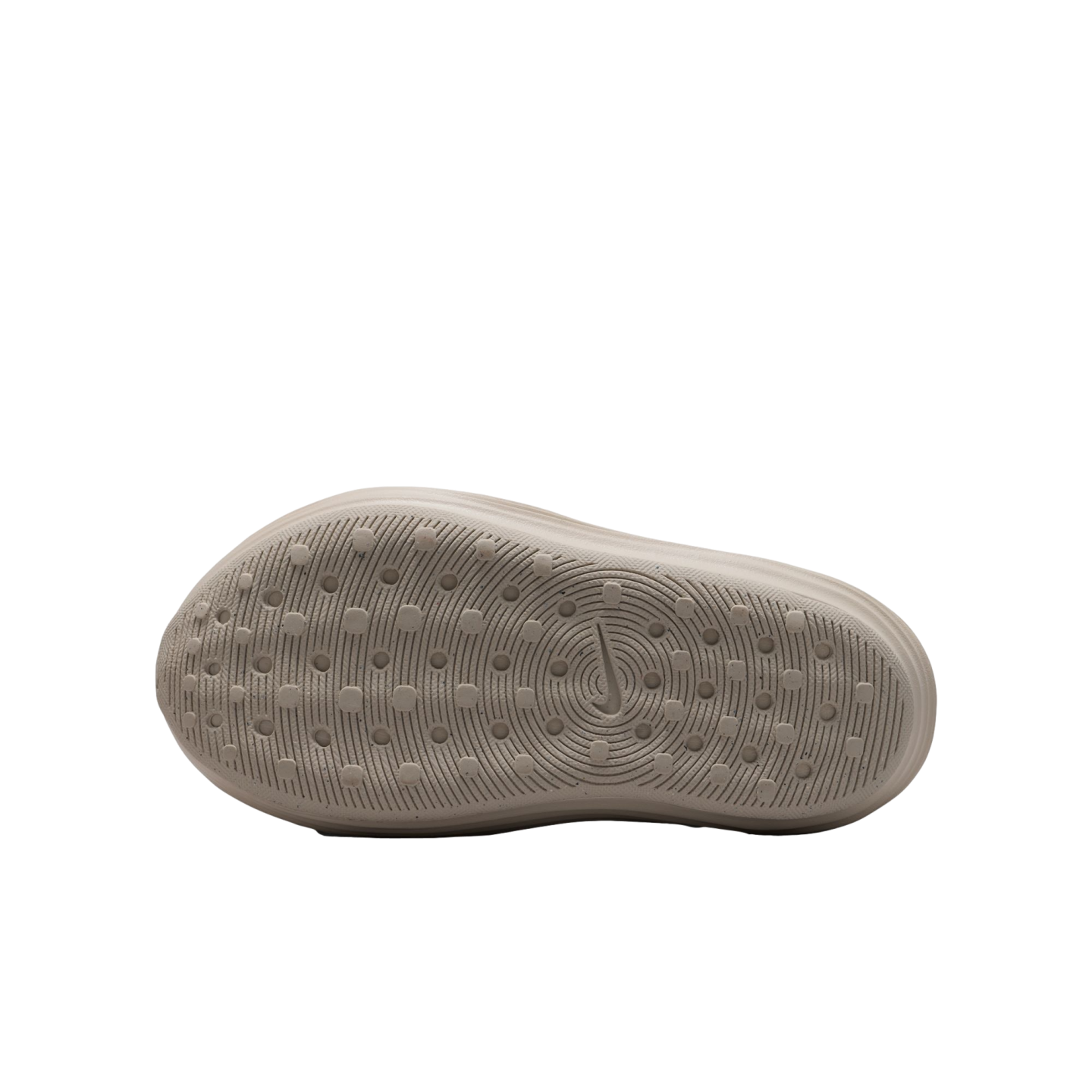The light beige underside of a Nike shoe featuring a textured traction pattern of concentric circles and small lugs on a solid black background.