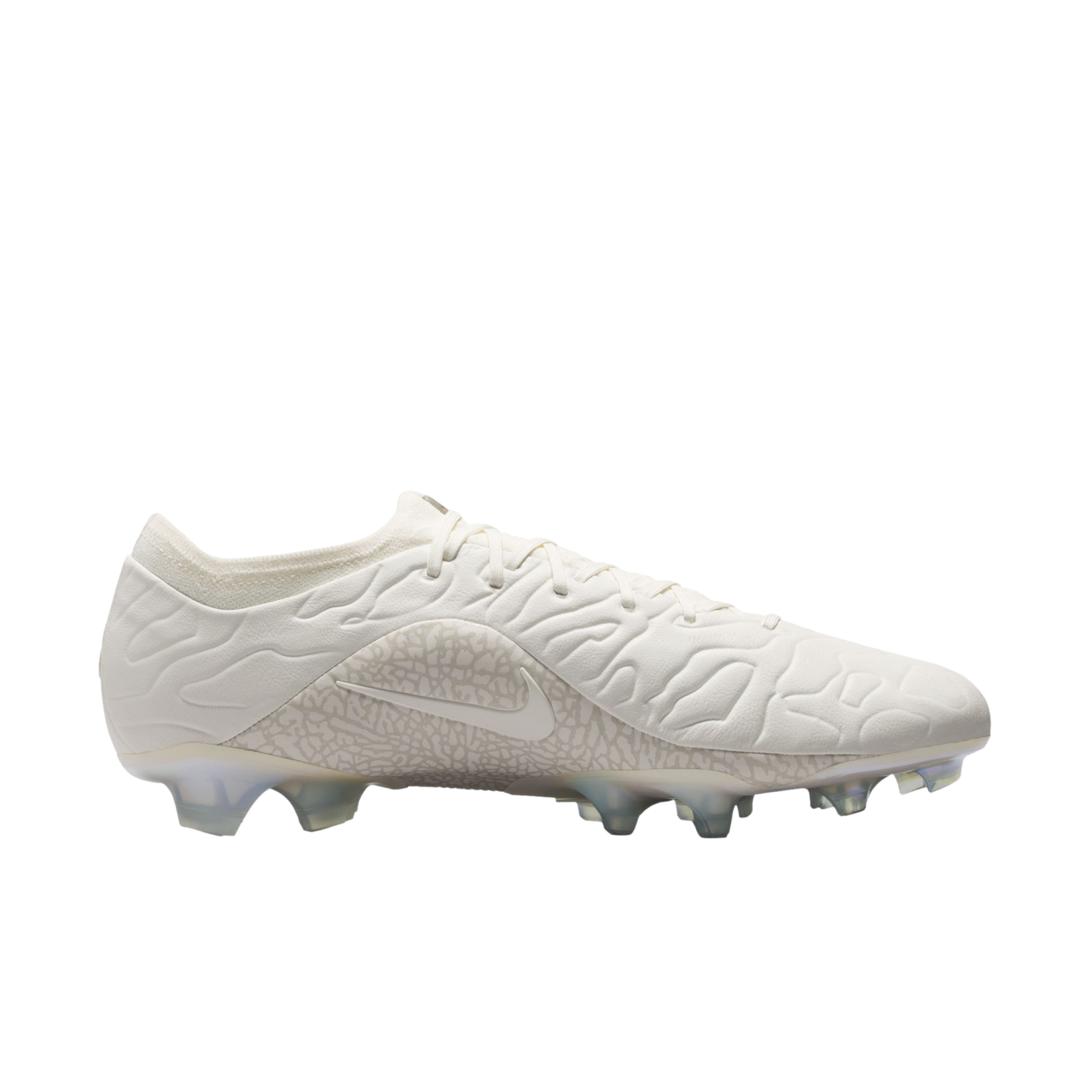 An off-white Nike soccer cleat with a textured upper and clear studs, shown from a side profile against a white background.