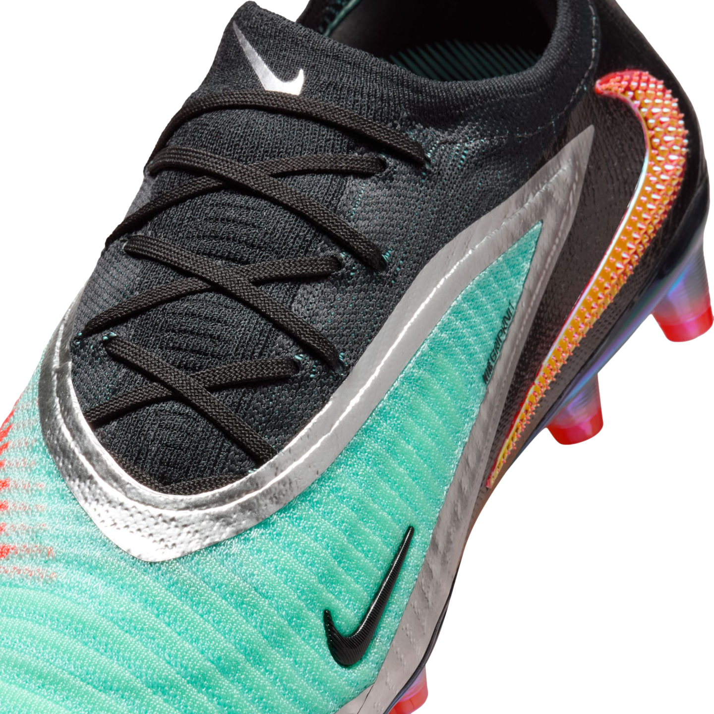 Close-up of a teal and black Nike soccer cleat with silver accents and iridescent swoosh details.