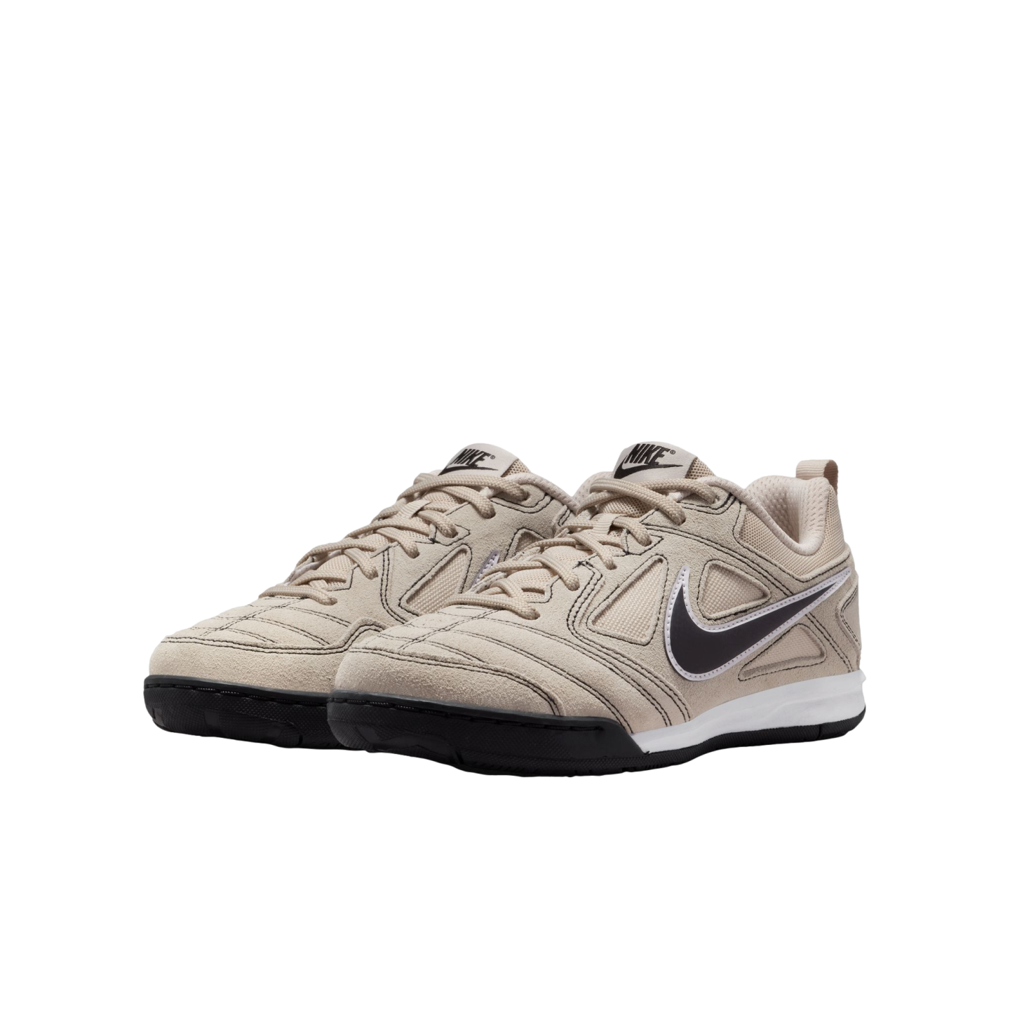 A pair of beige Nike low-top sneakers with black swooshes and soles, set against a solid black background.
