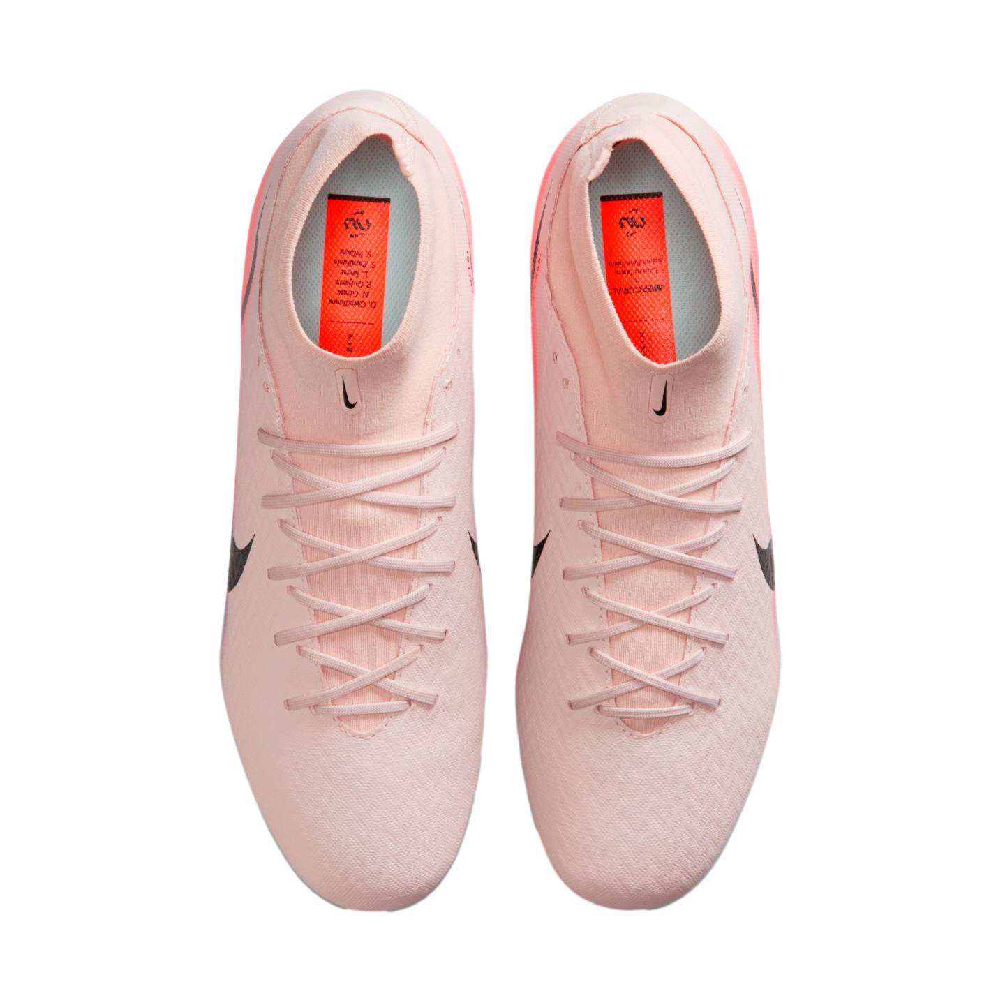 Top-down view of light pink Nike soccer cleats with matching laces and orange insoles on a black background.