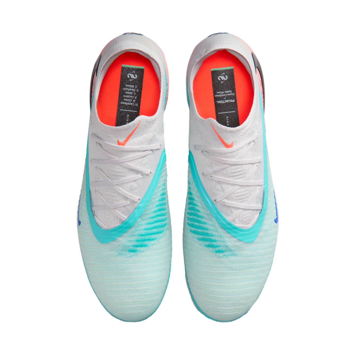 A top-down view of a pair of light blue Nike Phantom football boots with white laces, teal accents, and bright orange insoles on a black background.