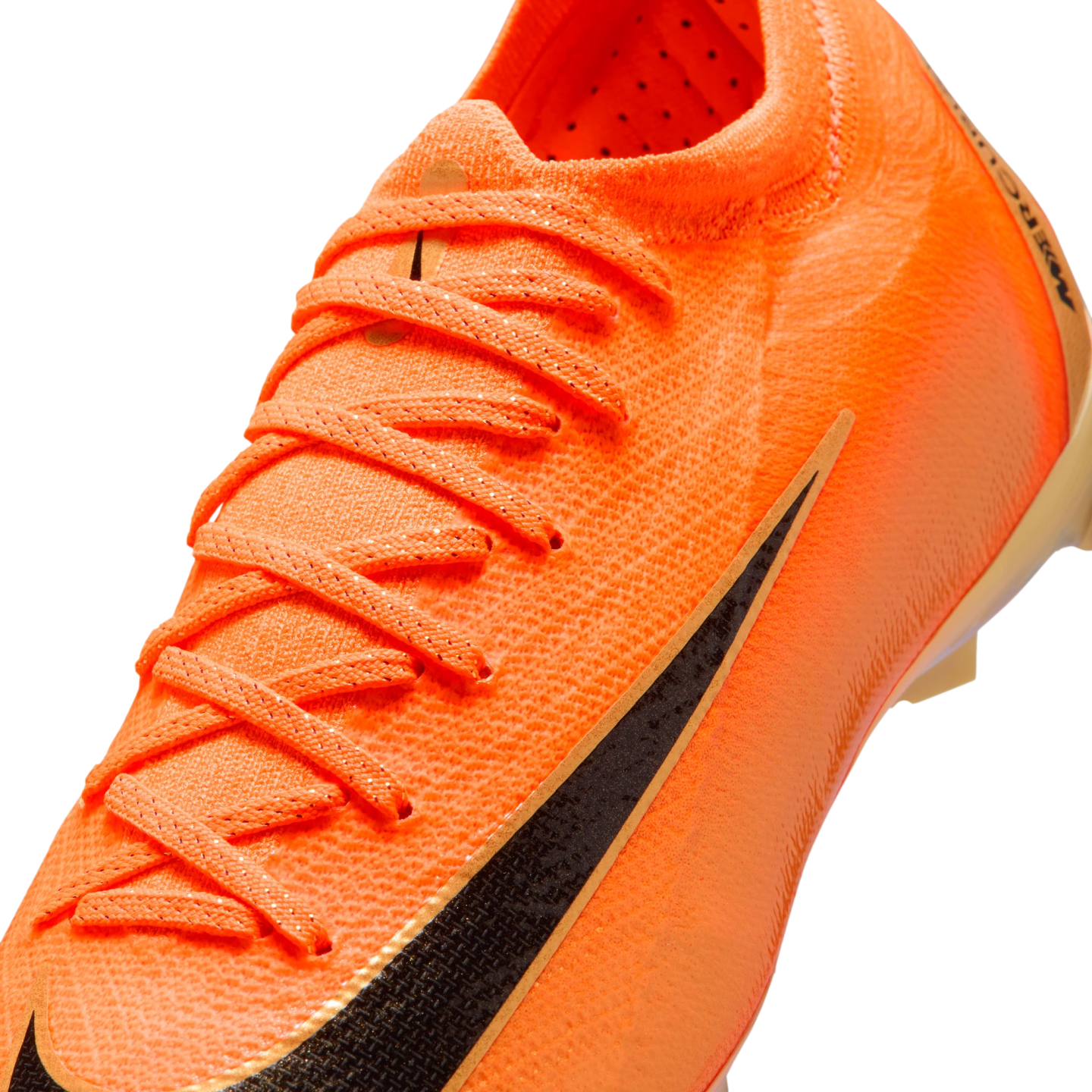 A close-up of a bright orange Nike soccer cleat with a textured surface, orange laces, and a large black swoosh on the side.