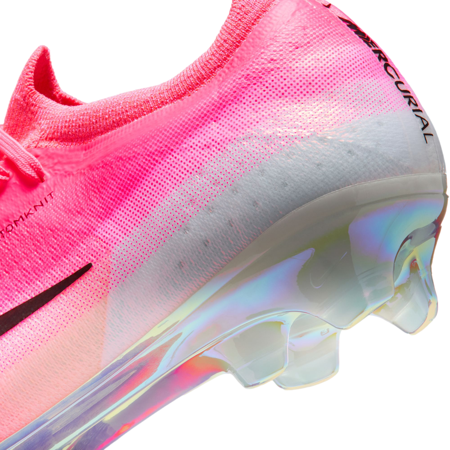 Close-up of a pink Nike Mercurial soccer cleat featuring a textured Flyknit upper, white heel, and an iridescent pearlescent sole plate.