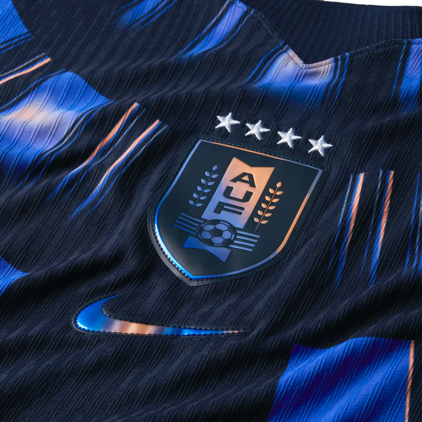 Close-up of a dark blue textured Uruguay soccer jersey featuring the AUF crest with four stars and a metallic Nike swoosh.