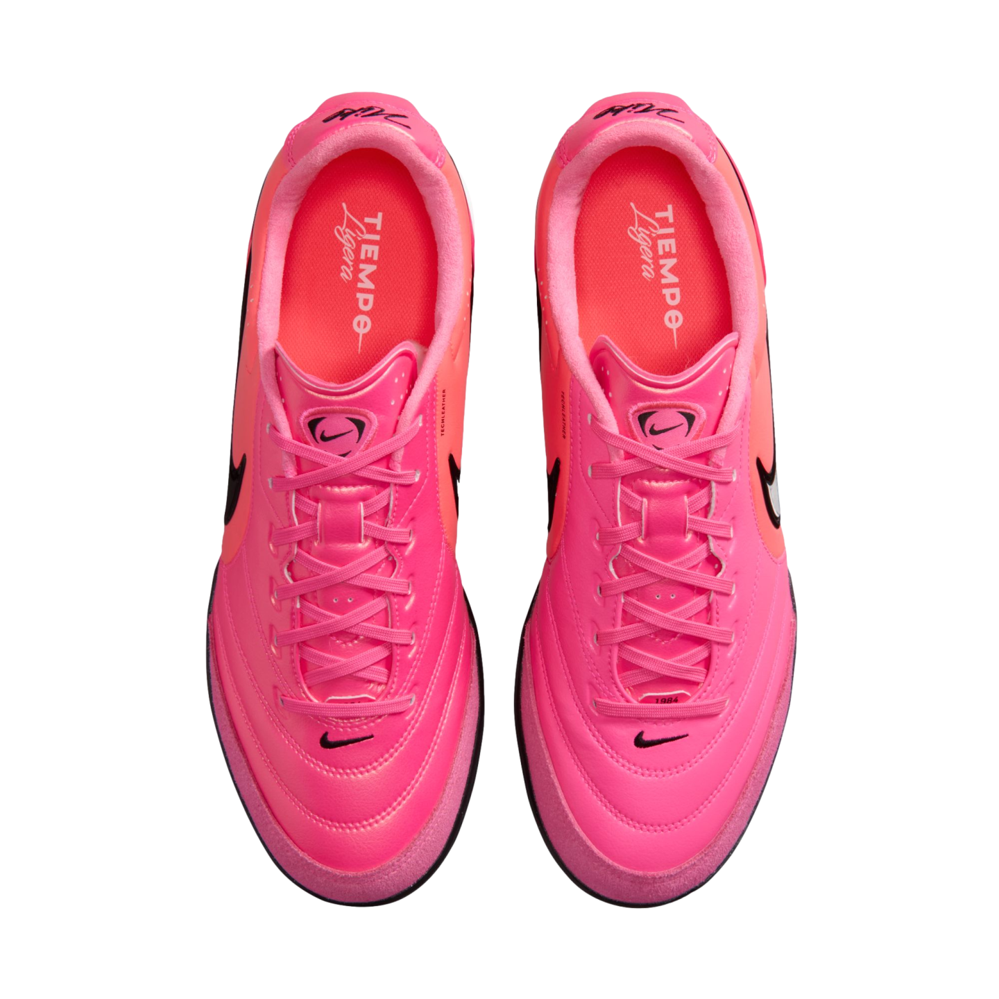 A top-down view of a pair of vibrant pink Nike Tiempo Ligera sneakers with matching pink laces and black branding on a white background.