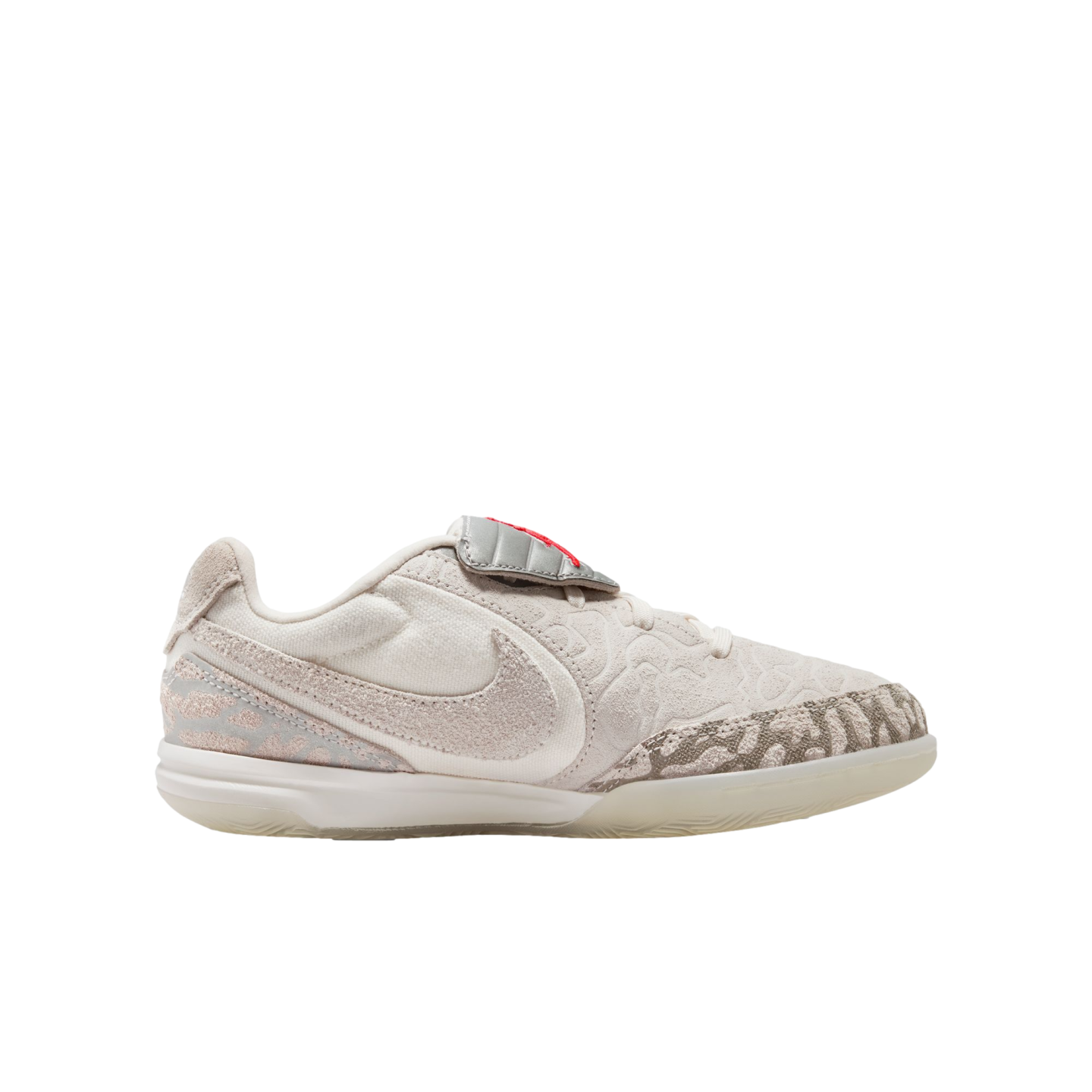 Side profile of a cream Nike low-top basketball shoe with intricate grey textured overlays, a large white Swoosh, and a translucent outsole on a black background.