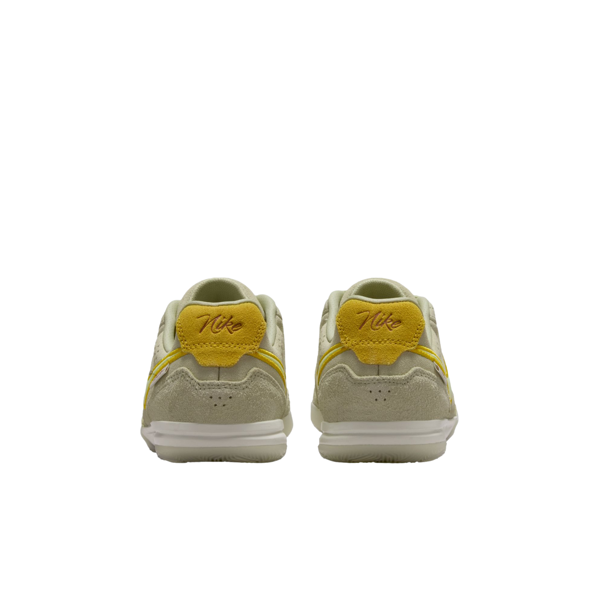 A rear view of two light green Nike sneakers with yellow accents and script "Nike" heel tabs, set against a solid black background.