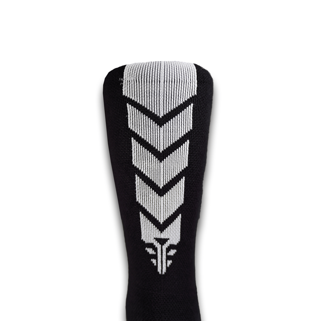 A close-up view of the For The Footballer XLR8R Pro No Slip Socks - Black, featuring a bold white vertical chevron pattern on the back of the calf.