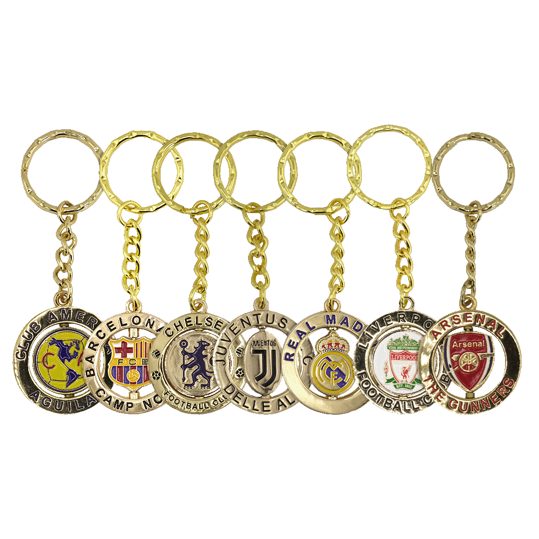 Seven gold-colored keychains featuring soccer club crests for Club América, Barcelona, Chelsea, Juventus, Real Madrid, Liverpool, and Arsenal.