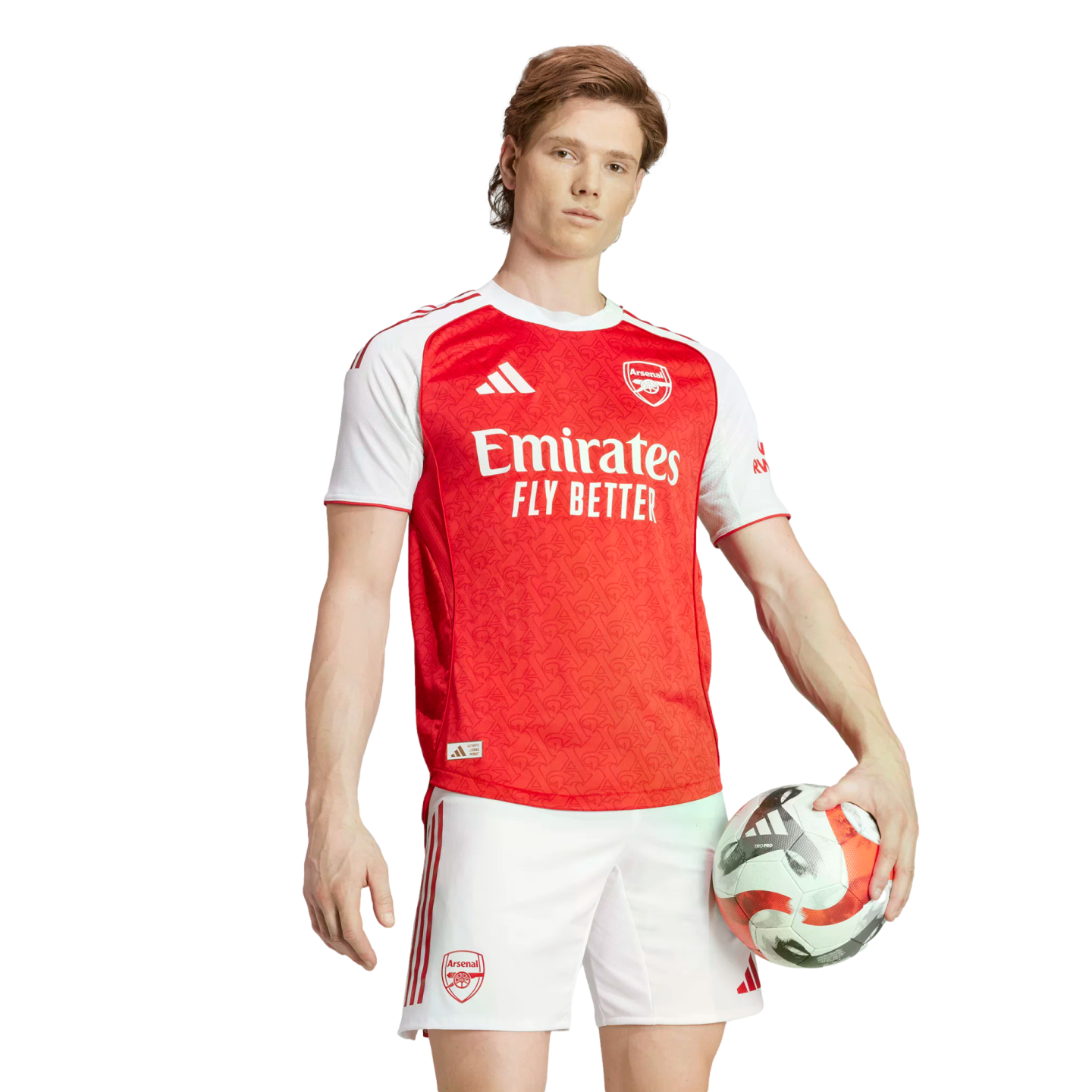 A young man in a red and white Arsenal home football kit holds a soccer ball against a white background.