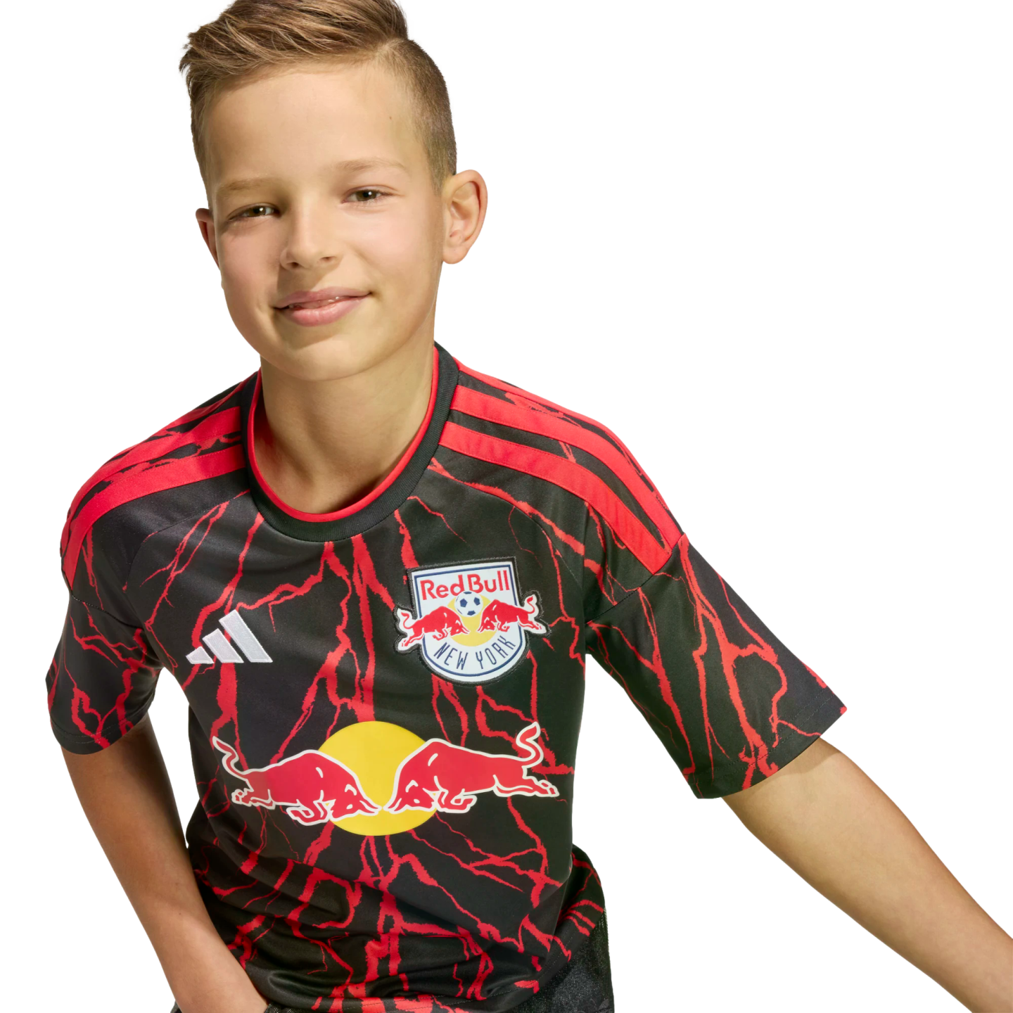 A young boy smiling while wearing a black and red New York Red Bulls soccer jersey.