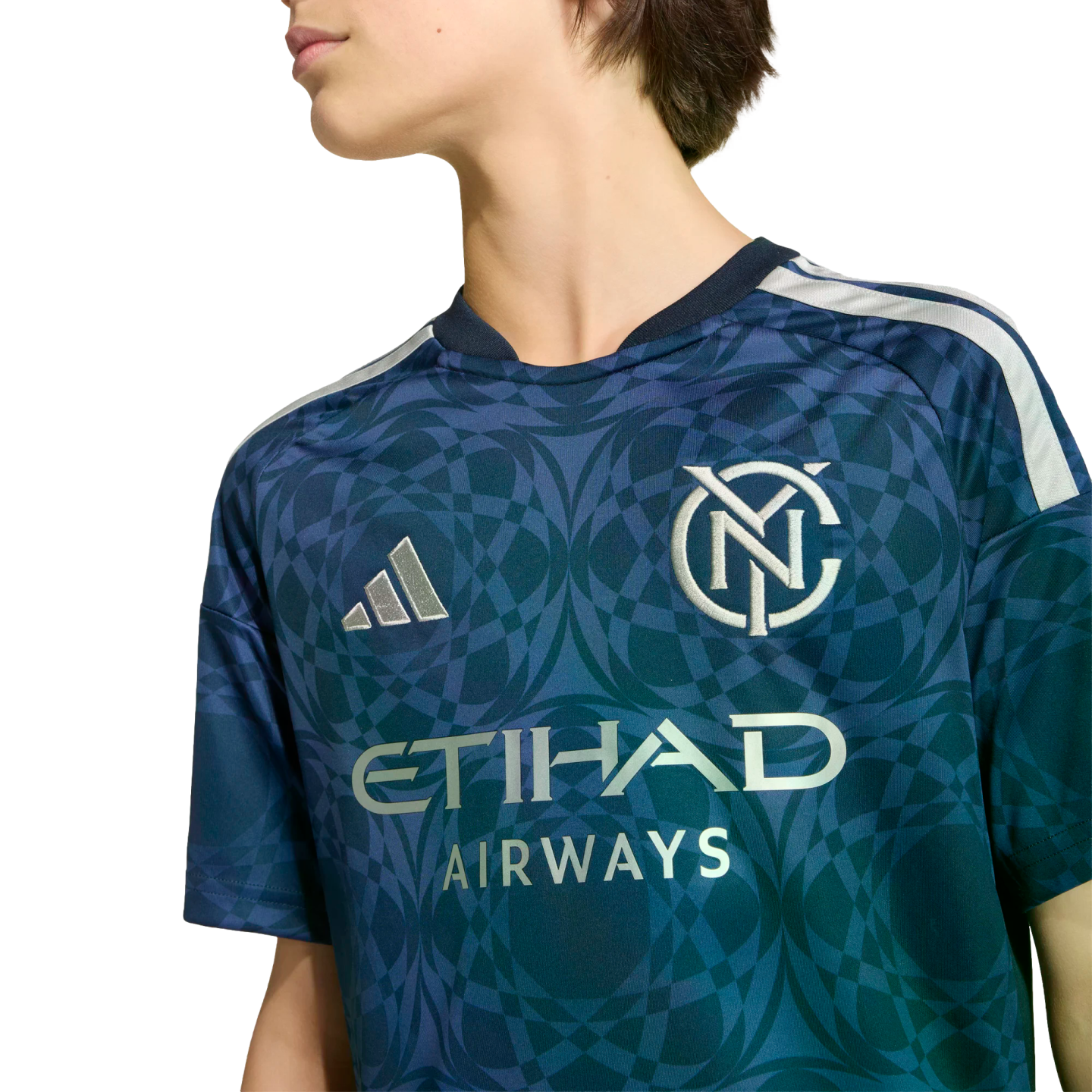 Person wearing a navy and teal New York City FC soccer jersey with a circular geometric pattern, Adidas logo, and Etihad Airways sponsor text.