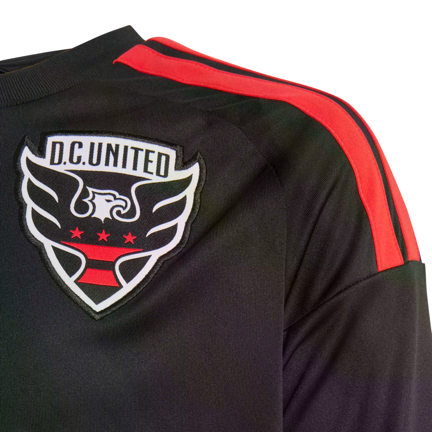 Close-up of a black D.C. United soccer jersey with red stripes on the shoulder and an embroidered team crest on the chest.