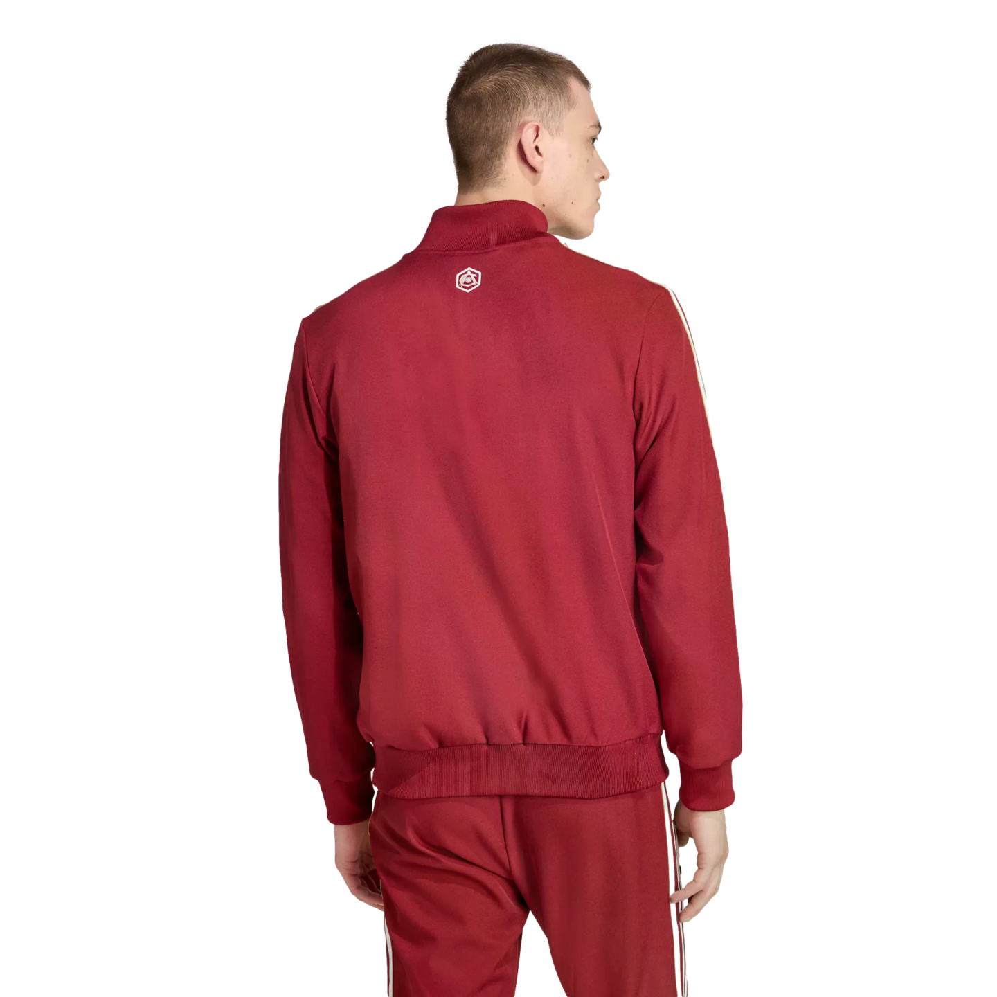 Back view of a man wearing a burgundy tracksuit with white side stripes and a small white logo on the upper back, set against a solid black background.