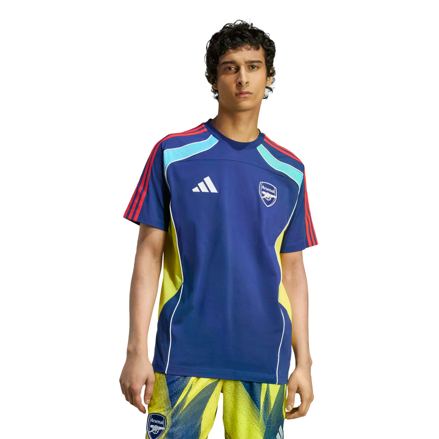 A man wearing a blue Adidas Arsenal F.C. training jersey with yellow accents and matching patterned shorts, standing against a black background.