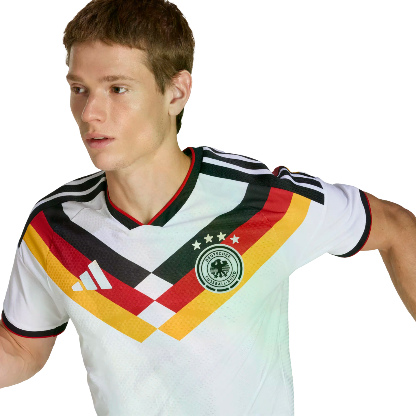 A man wearing a white German football jersey featuring a black, red, and yellow chevron design, looking to his left against a solid black background.
