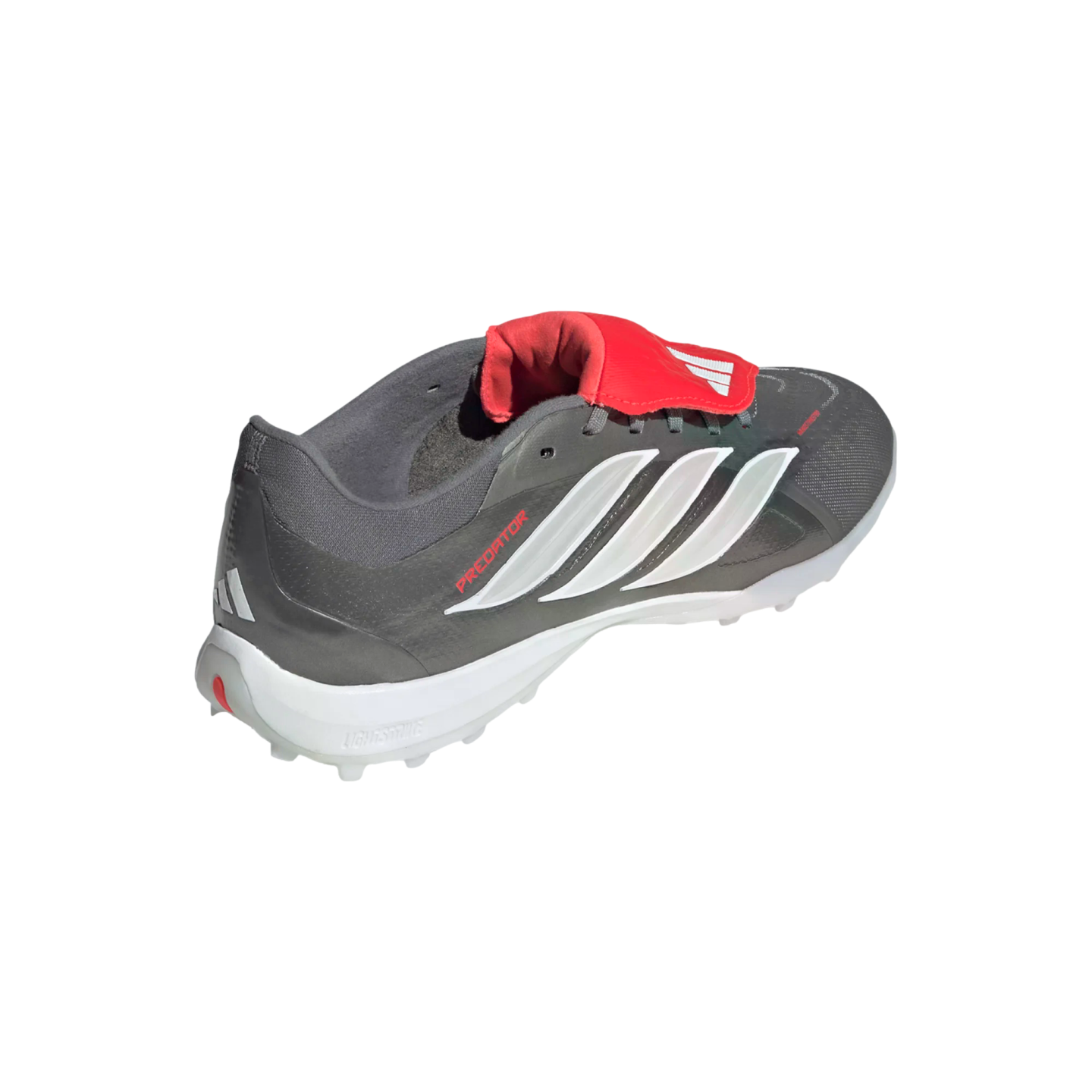A gray and white Adidas Predator soccer turf shoe featuring a red fold-over tongue and iconic white three-stripe branding.