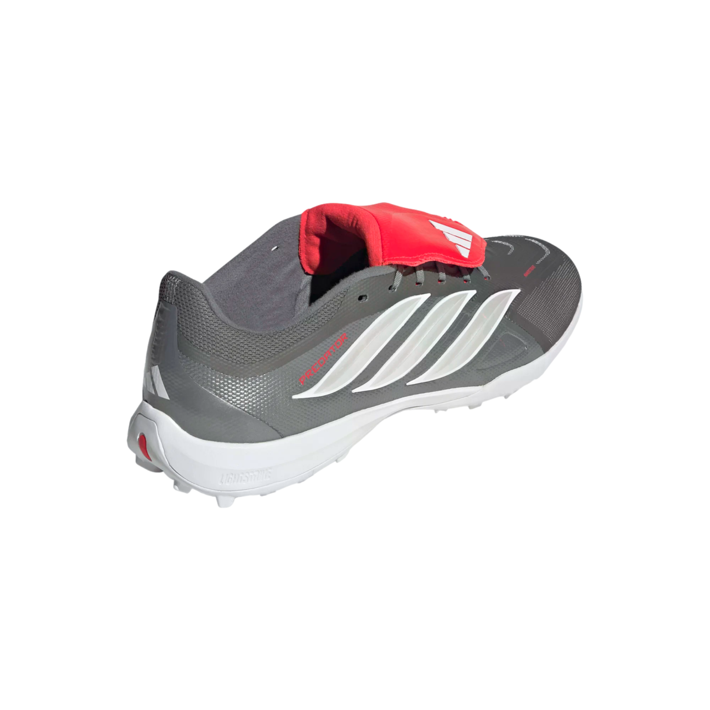 Grey Adidas Predator soccer shoe featuring white stripes and a red fold-over tongue, shown from a rear-quarter view on a black background.