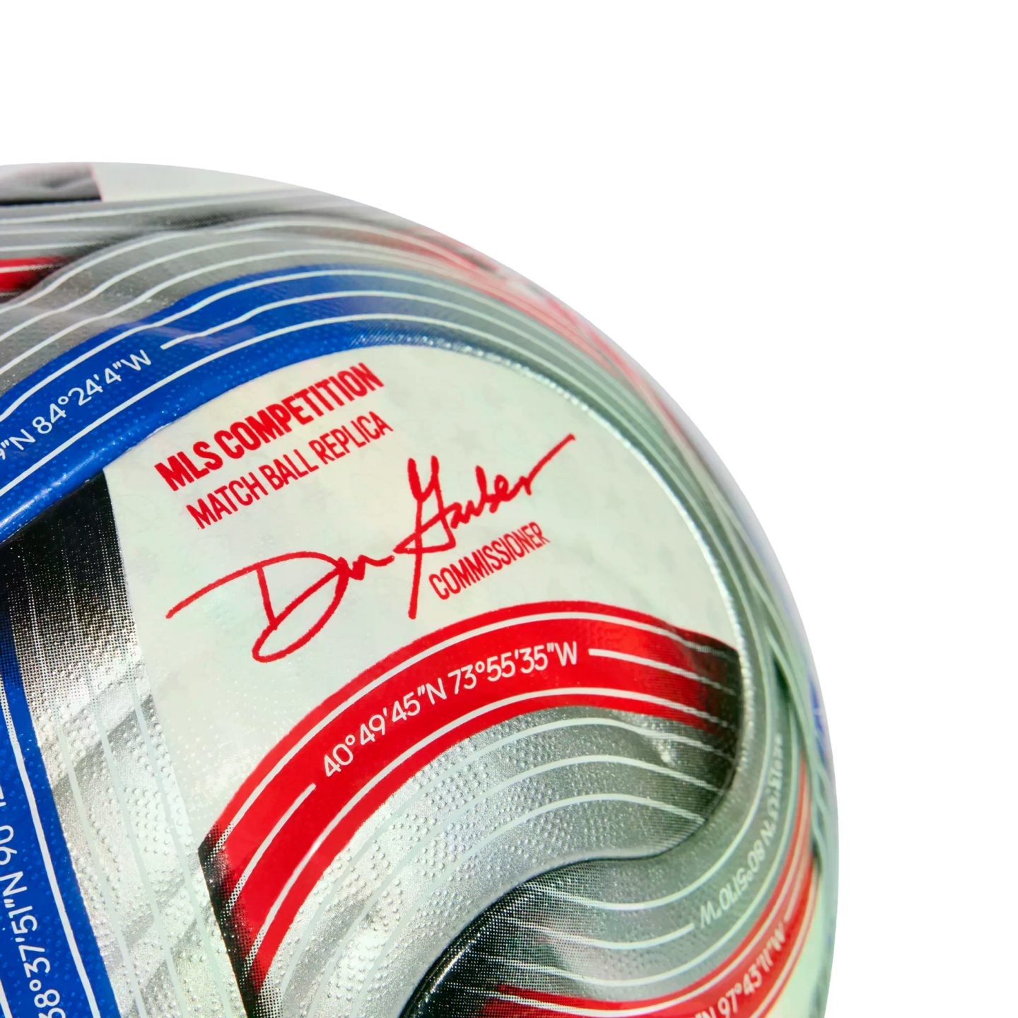 Close-up of an MLS match ball replica soccer ball featuring Commissioner Don Garber's signature and geographic coordinates on a silver, red, and blue graphic panel.