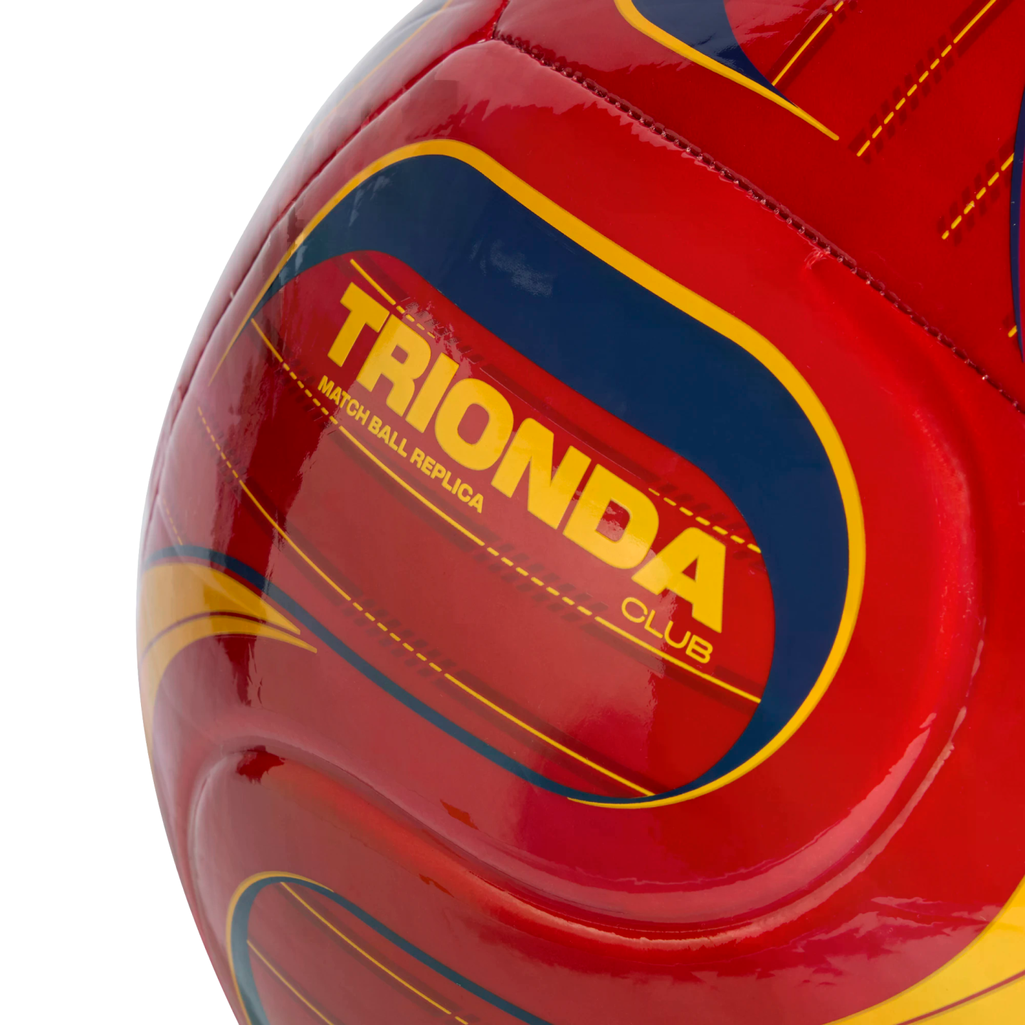 Close-up of a red soccer ball with yellow and blue graphics, featuring the yellow text "TRIONDA CLUB MATCH BALL REPLICA" against a black background.