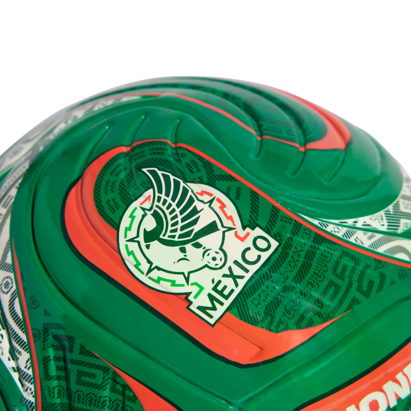 Close-up of a glossy green soccer ball featuring the Mexico national team crest, with red and white accents and textured patterns.