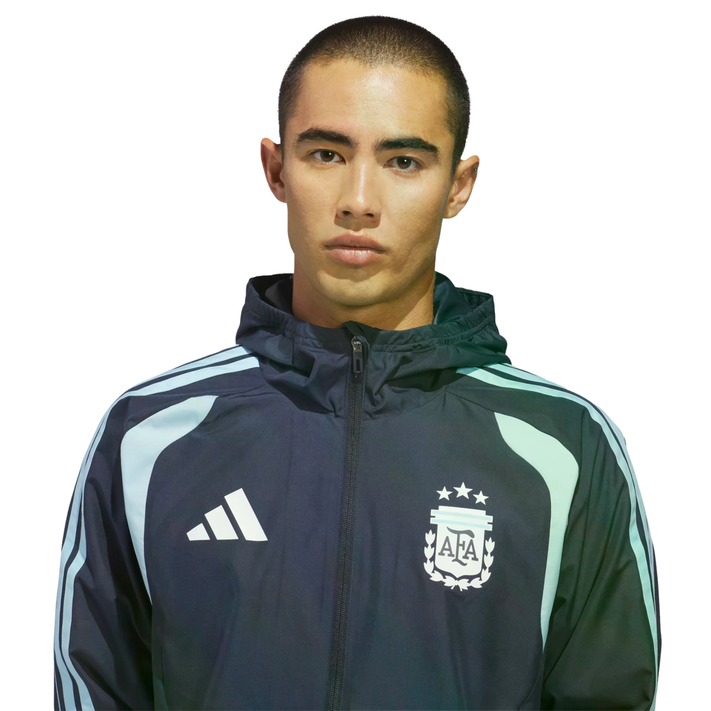 A man with a buzz cut wearing an Adidas Argentina national football team zip-up jacket against a black background.