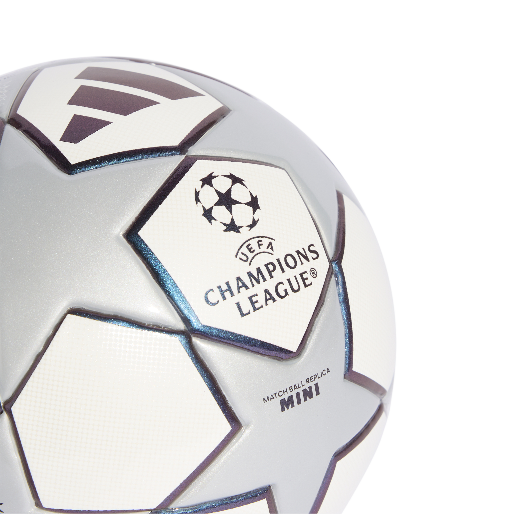 Close-up of a silver and white UEFA Champions League mini replica soccer ball with star panels and logos on a solid black background.