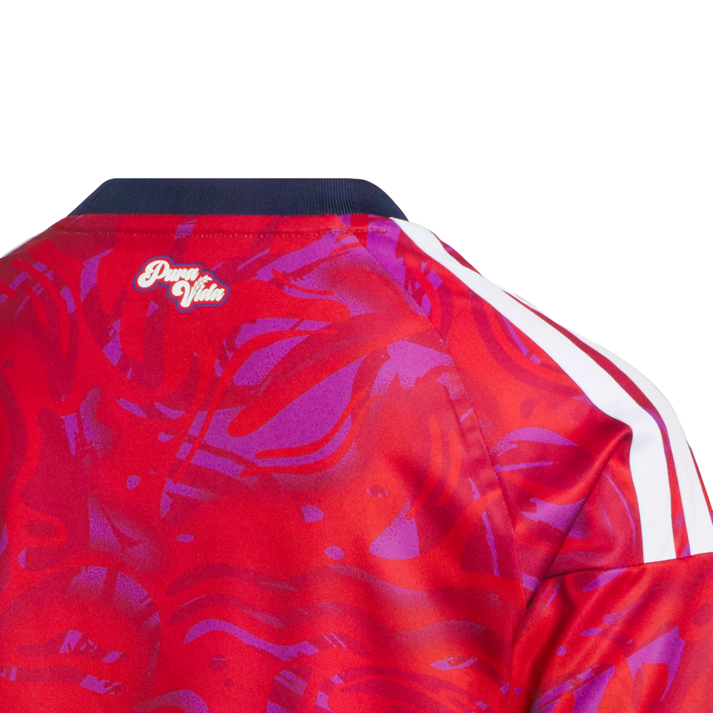 Close-up back neck view of a red and purple patterned jersey with a navy collar, "Pura Vida" script logo, and white shoulder stripes.