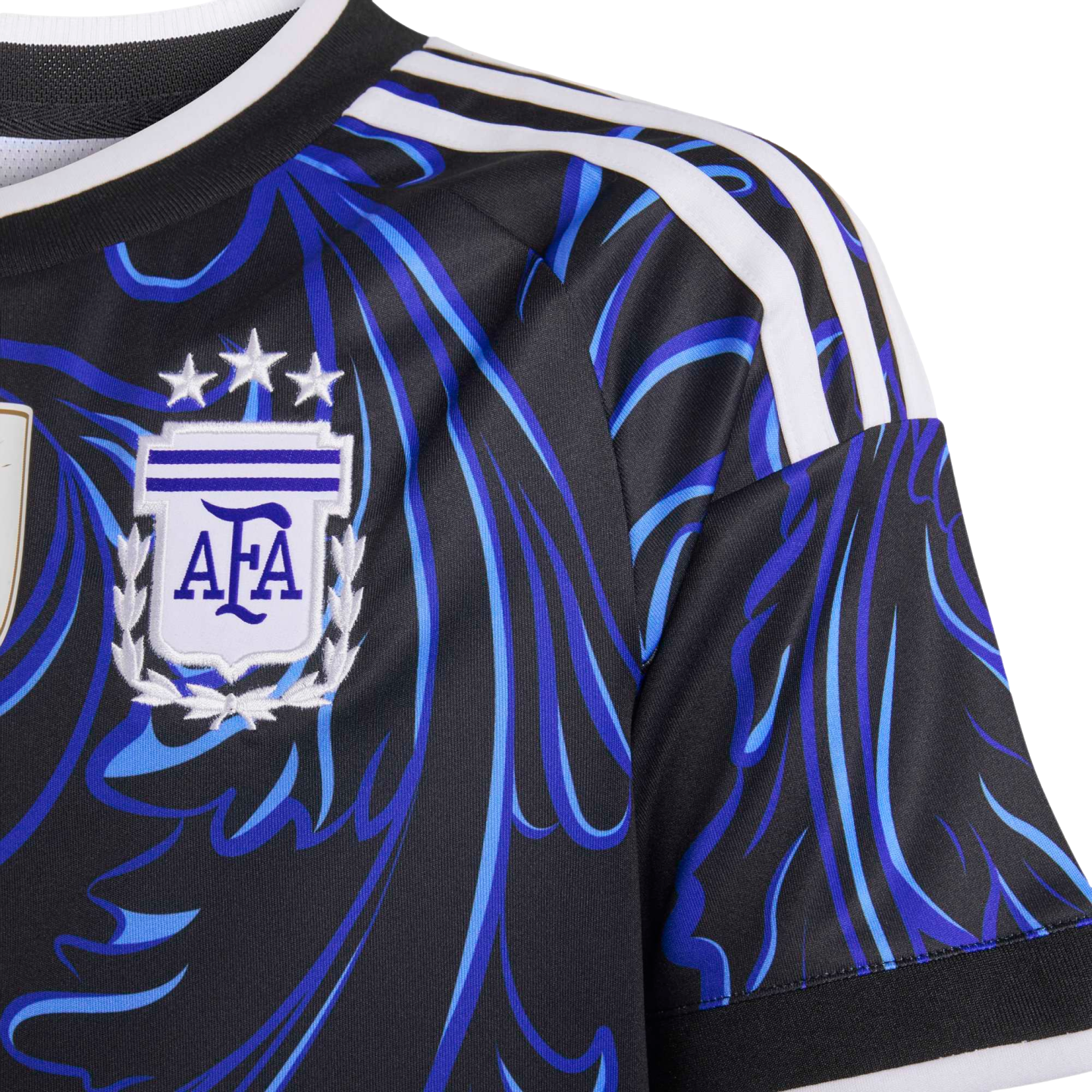 Close-up of a black Argentina soccer jersey with blue abstract patterns, three white shoulder stripes, and the AFA crest topped with three stars.