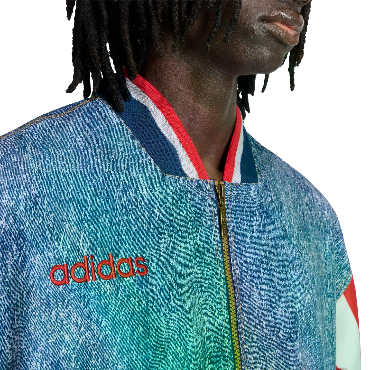 Close-up of a person in a blue denim-textured Adidas jacket with a red logo and striped collar.