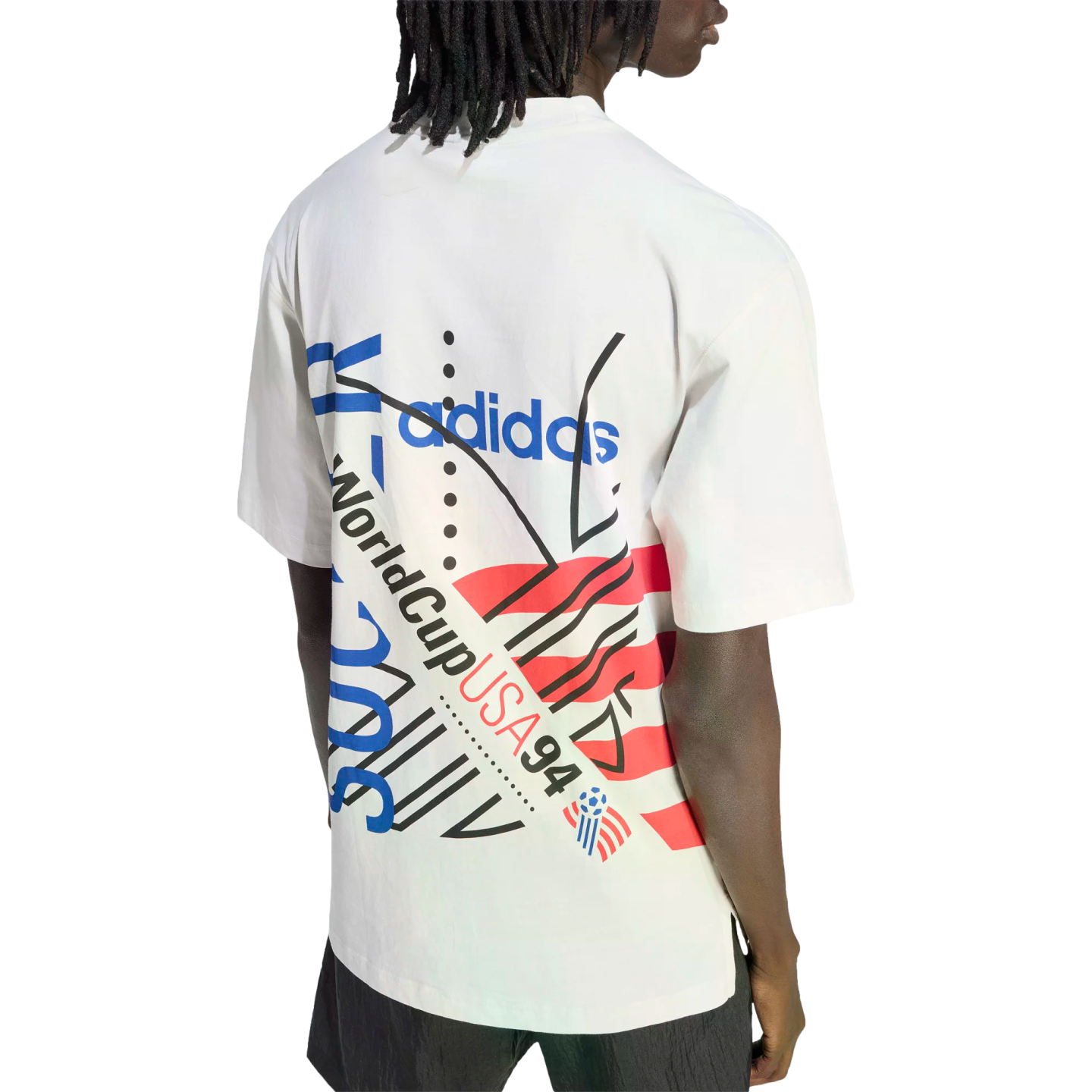 Rear view of a person with dreadlocks wearing a white Adidas t-shirt featuring a colorful "World Cup USA 94" graphic design on the back.