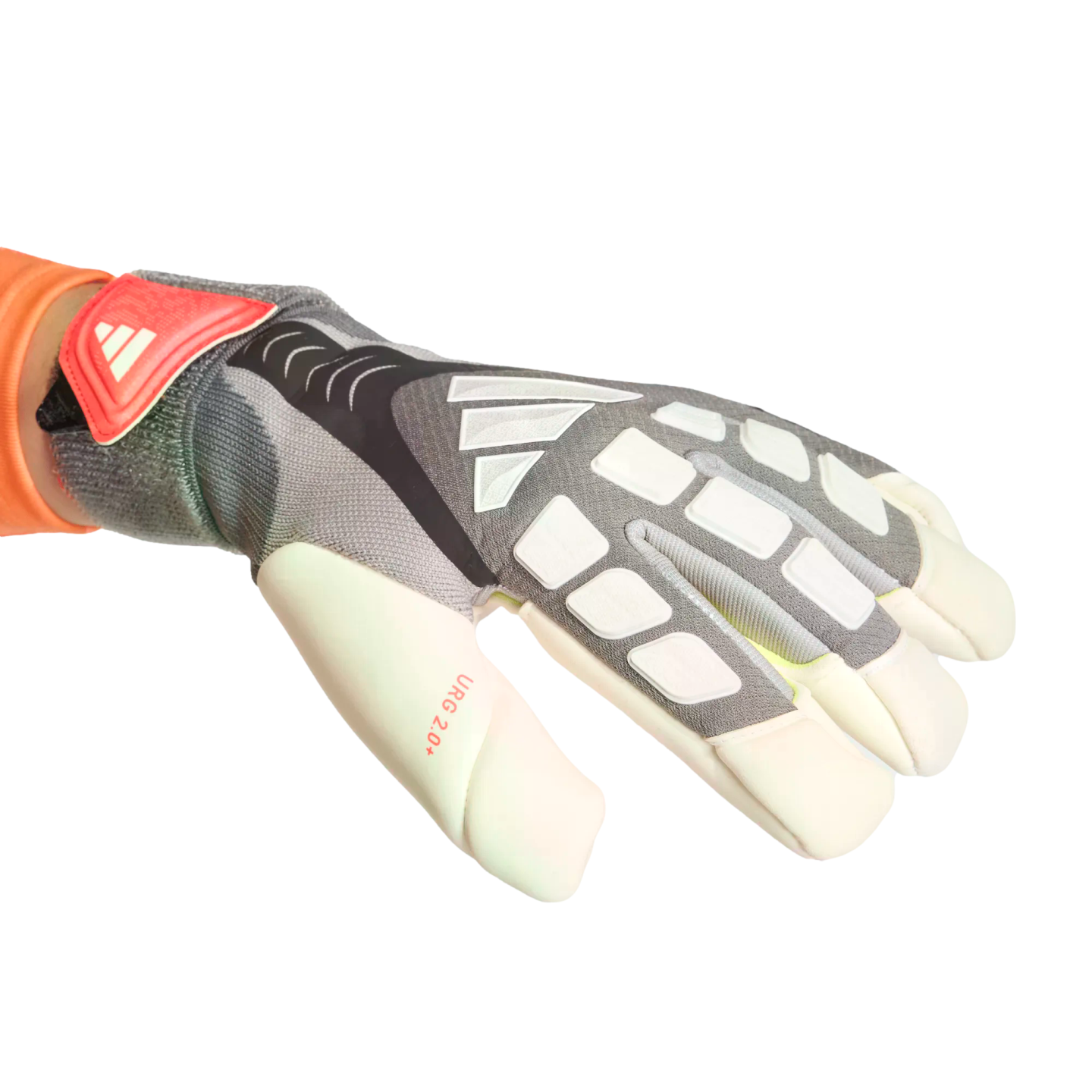 An Adidas goalkeeper glove in grey and white with orange accents, featuring the brand logo and "URG 2.0+" text on the thumb, worn on a hand against a black background.