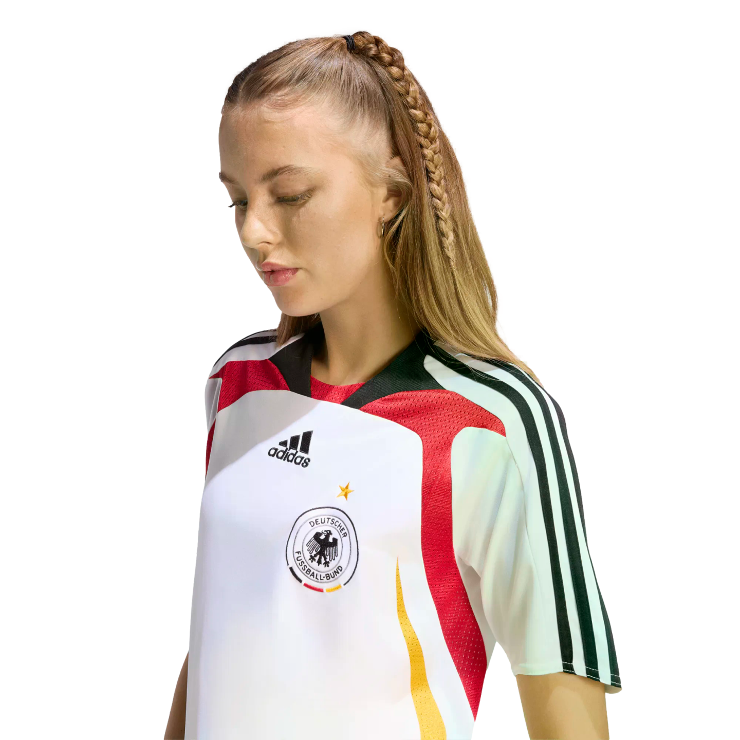 A woman with a long blonde braid looking down while wearing a white Adidas Germany national team soccer jersey.
