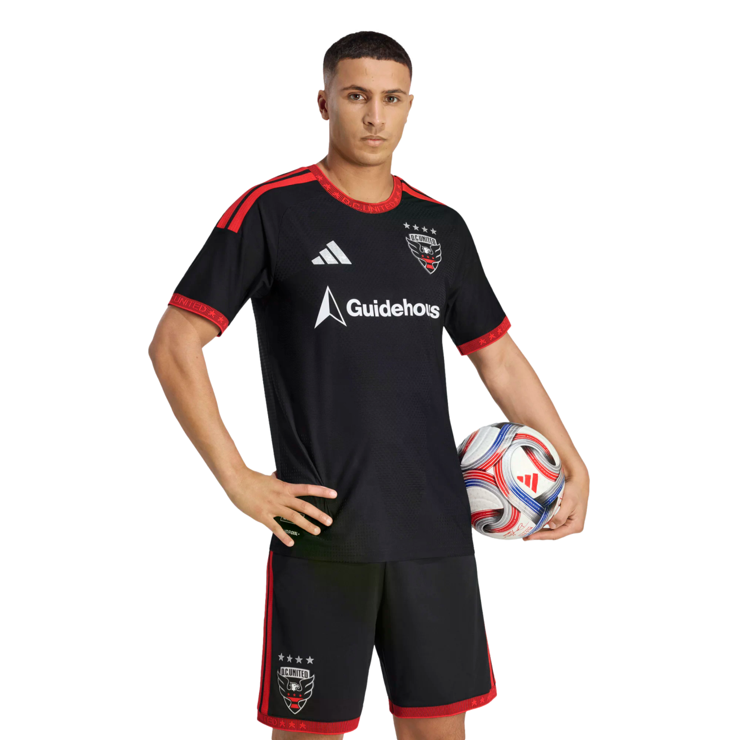 A D.C. United soccer player posing in the team's black and red home kit, holding a soccer ball against a black background.