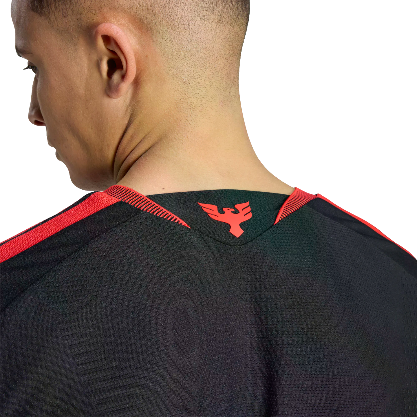 Close-up of a man's neck and the back of a black athletic jersey with a red phoenix logo on the collar and red shoulder stripes.